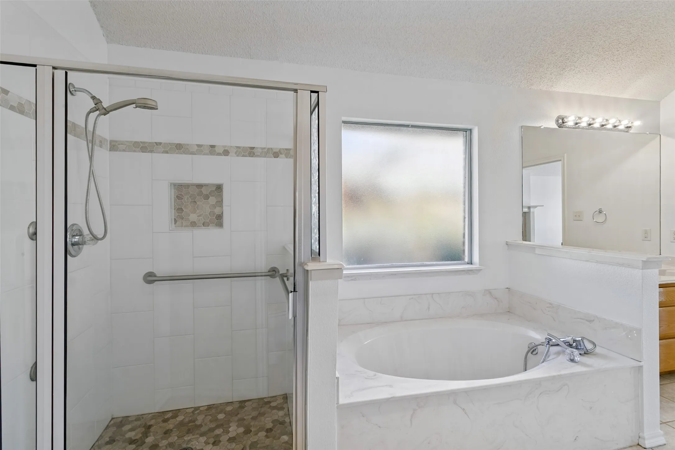 Spacious walk-in shower and soaking tub in the primary bathroom