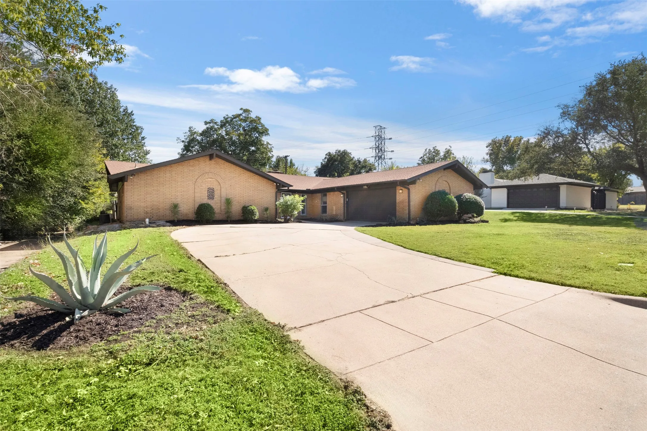The swing driveway provides convenient access to the attached two-car garage and additional parking space.