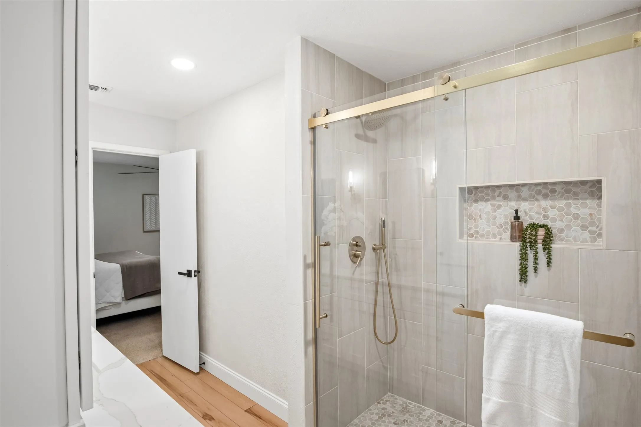 The beautifully finished primary shower includes a handheld showerhead for added convenience.