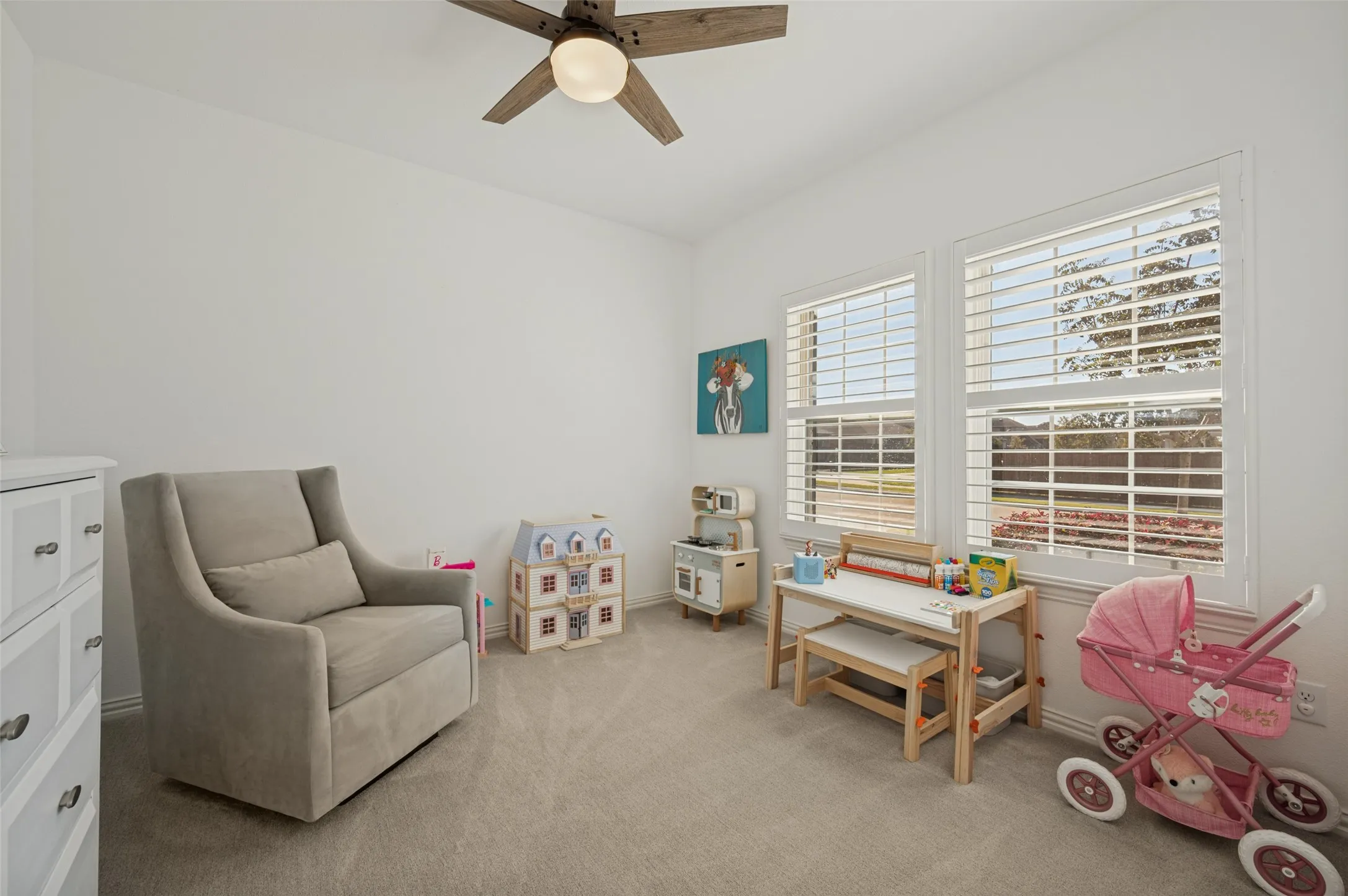 Neutral-toned carpeted flooring, dual windows featuring adjustable shutters, and a ceiling fan with integrated lighting