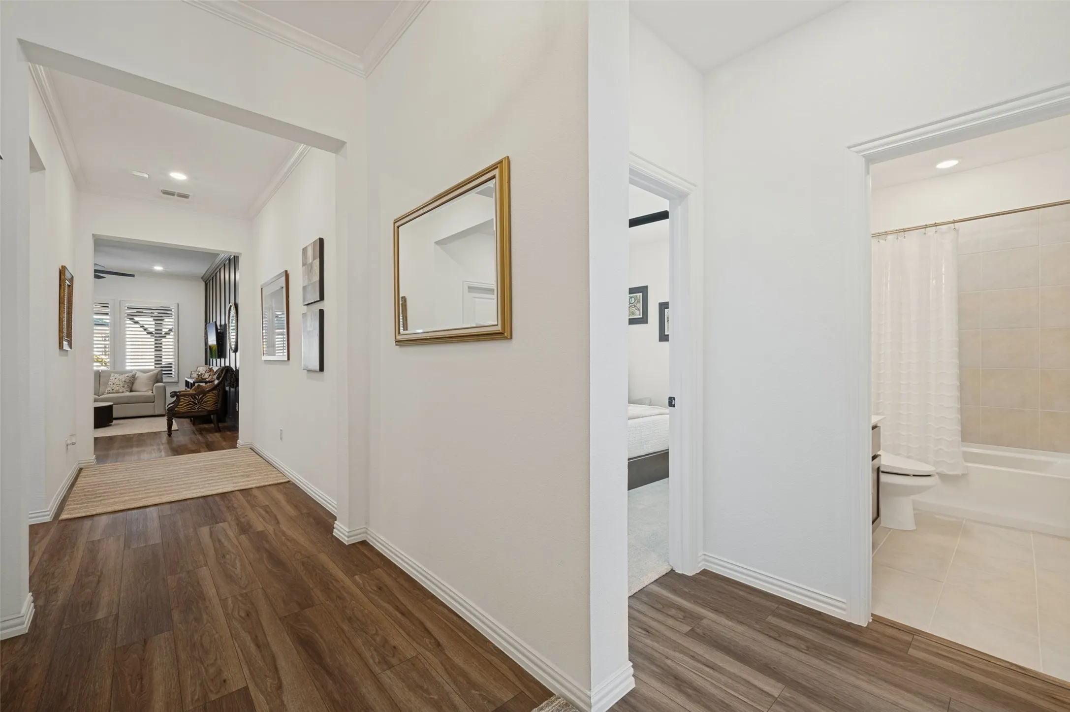 Interior hallway featuring wood-finish flooring, crisp white walls, crown molding, and recessed lighting
