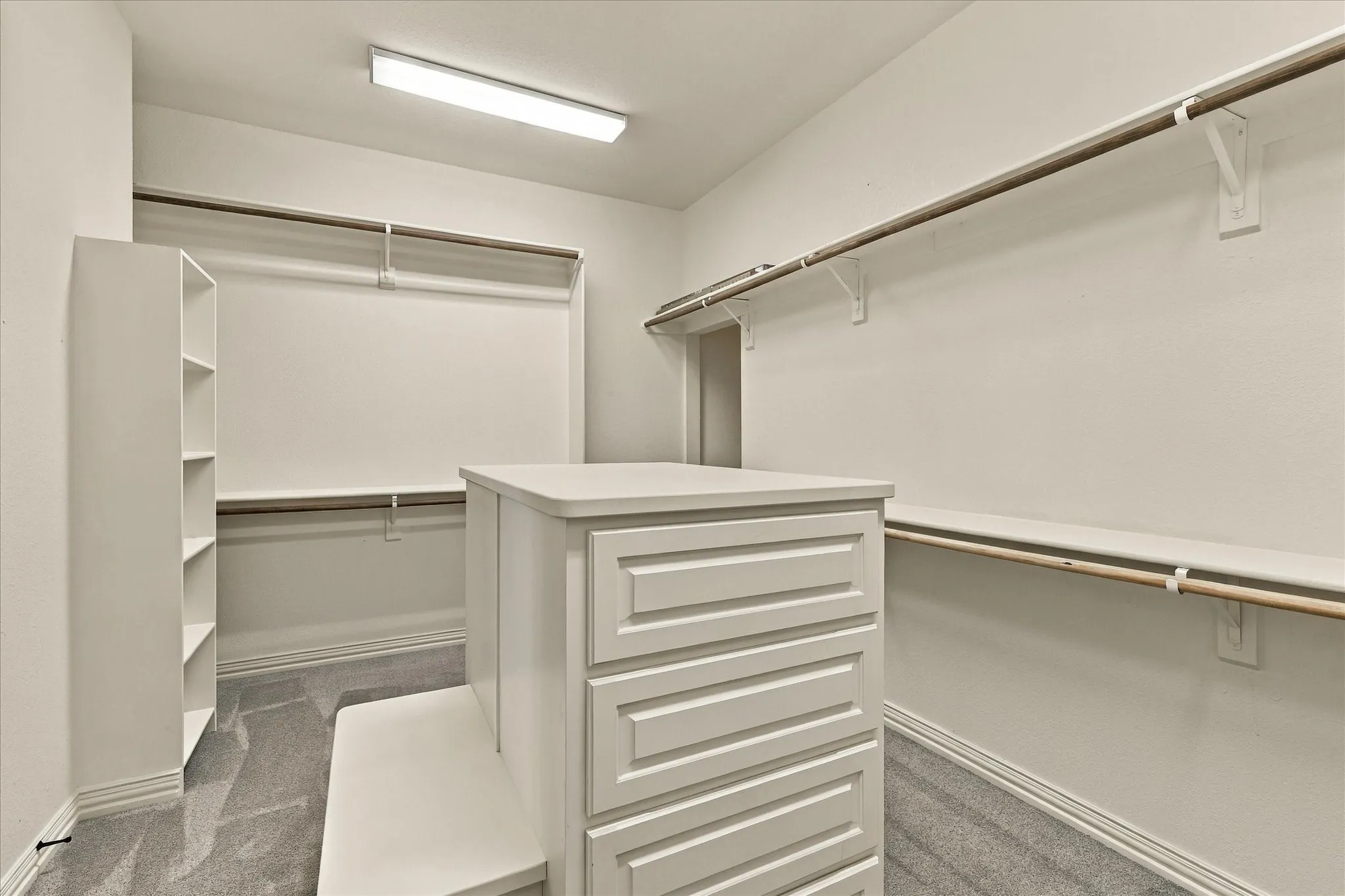 HUGE master closet with built-in center dresser and bench