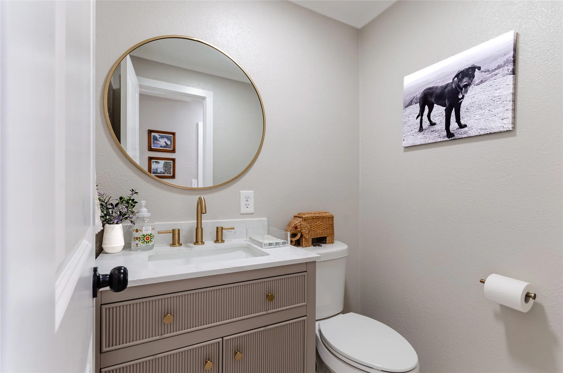 Vanity with fluted paneling and brass-finish hardware, rectangular undermount sink, white countertop, and brass-finish faucet