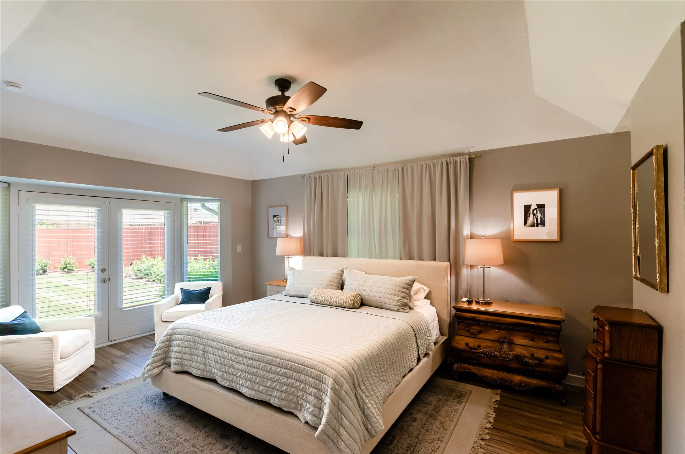 Tray ceiling with a ceiling fan, French doors with integrated blinds, wood-finish flooring, and neutral wall tones