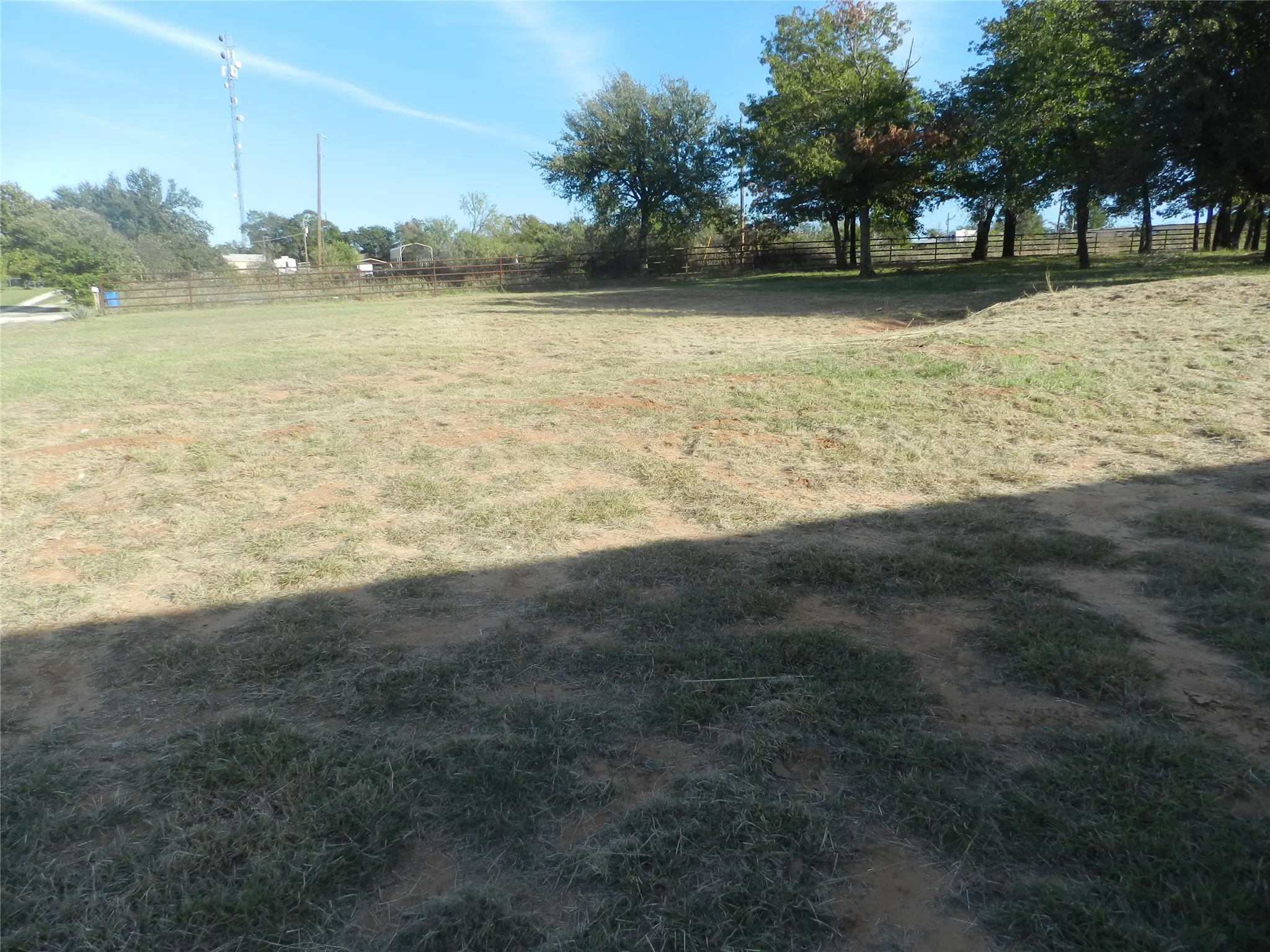 Expansive lot featuring mature trees and perimeter fencing