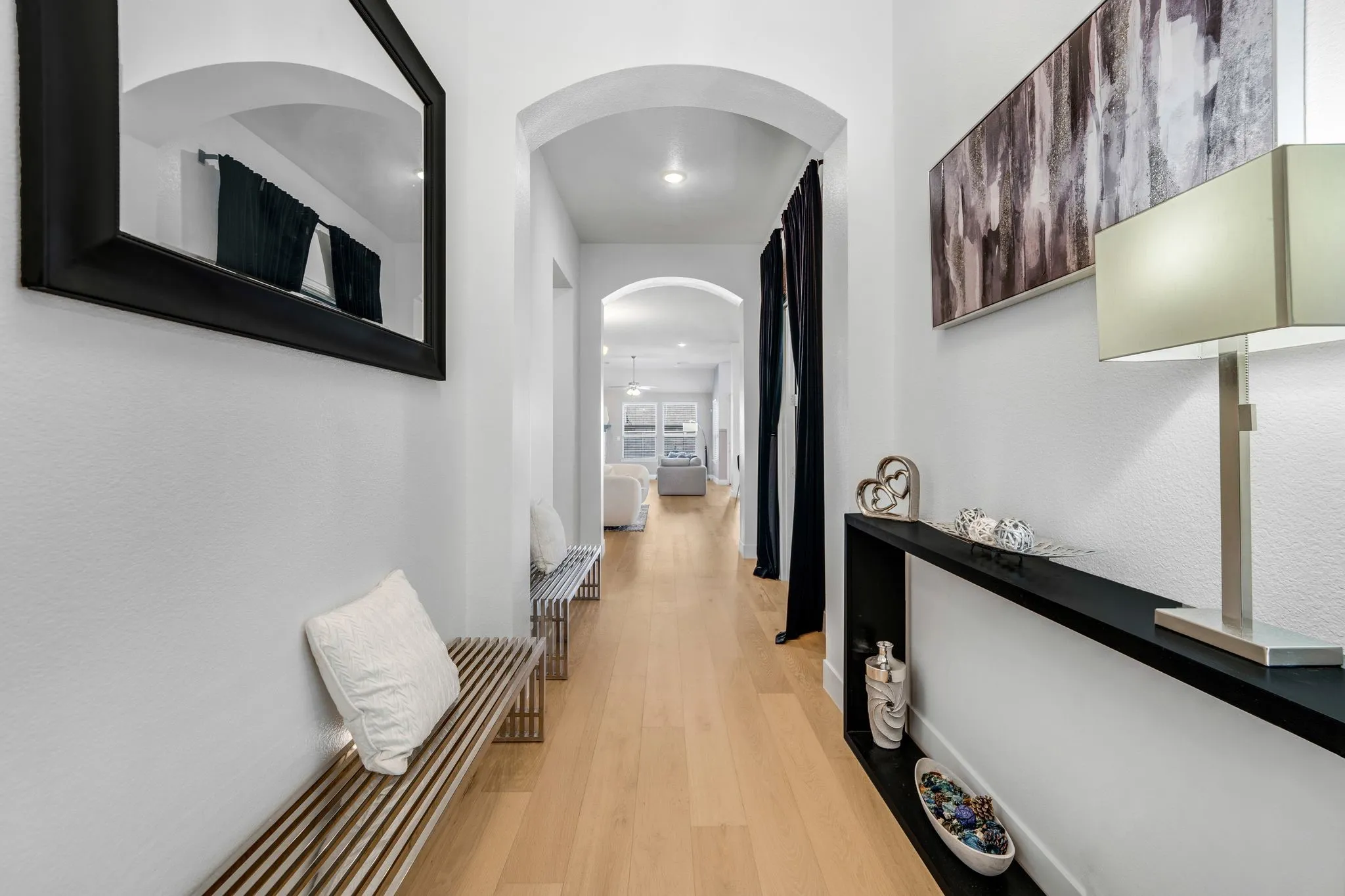 Entryway featuring light-toned wood-finish flooring and dual architectural archways