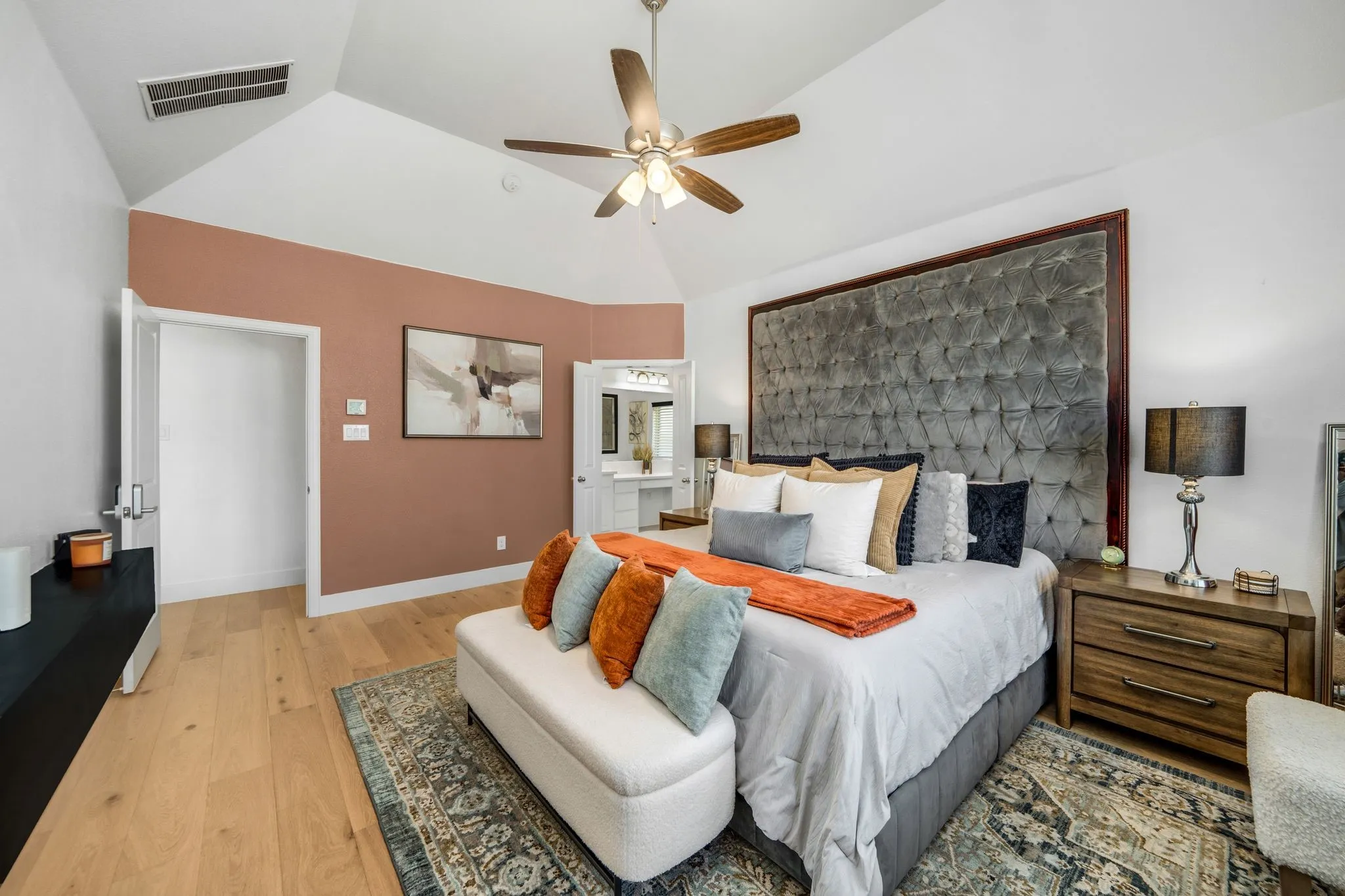Vaulted ceiling featuring a central multi-blade ceiling fan with integrated lighting and wood-finish flooring