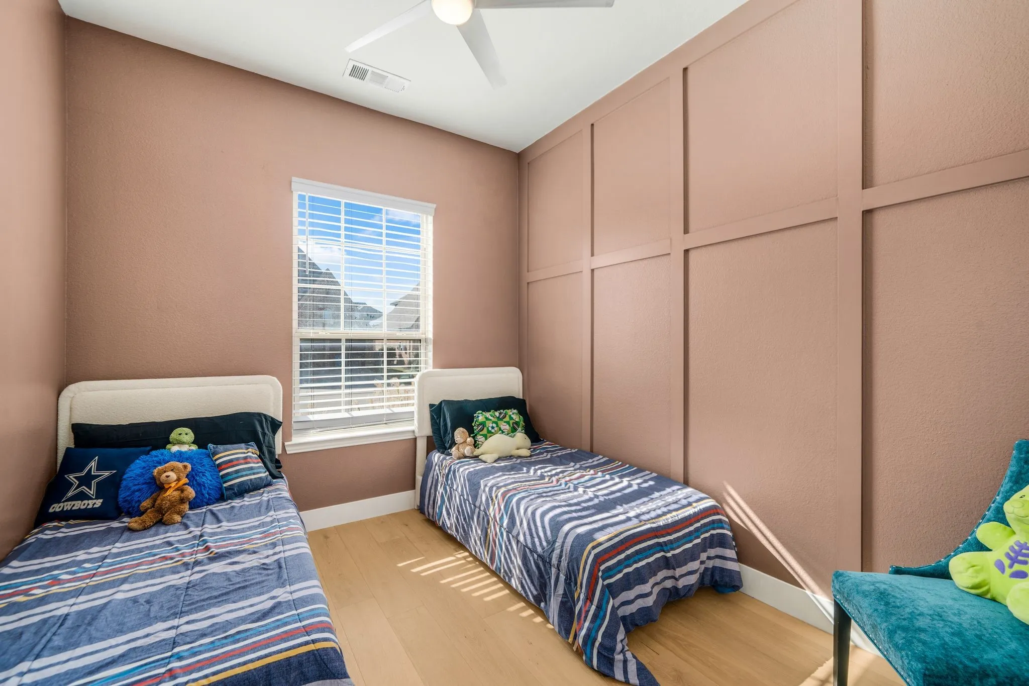 Interior space featuring wood-finish flooring, a wall with decorative molding, and a ceiling-mounted light fixture