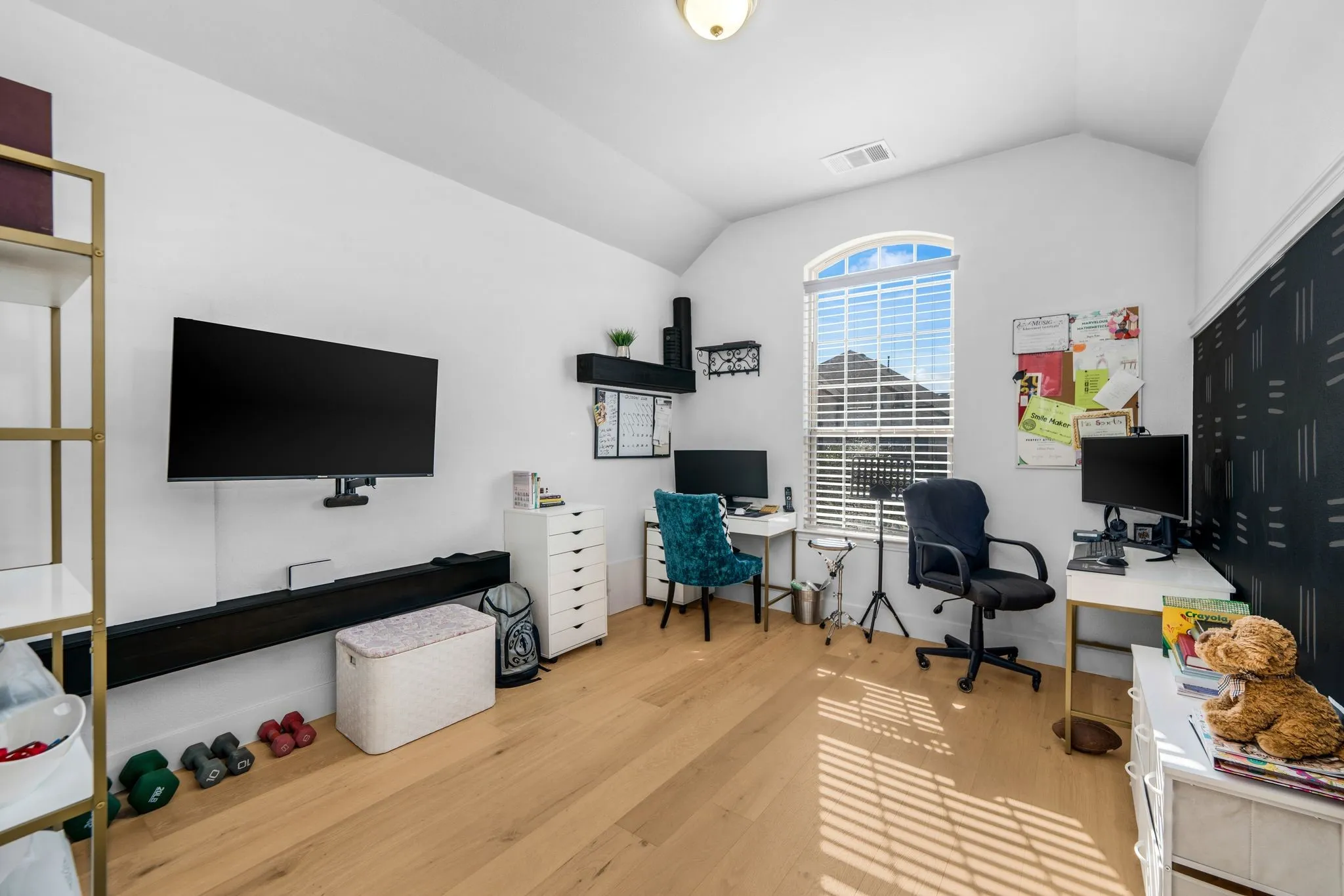 Vaulted ceiling, wood-finish flooring, and an arched window