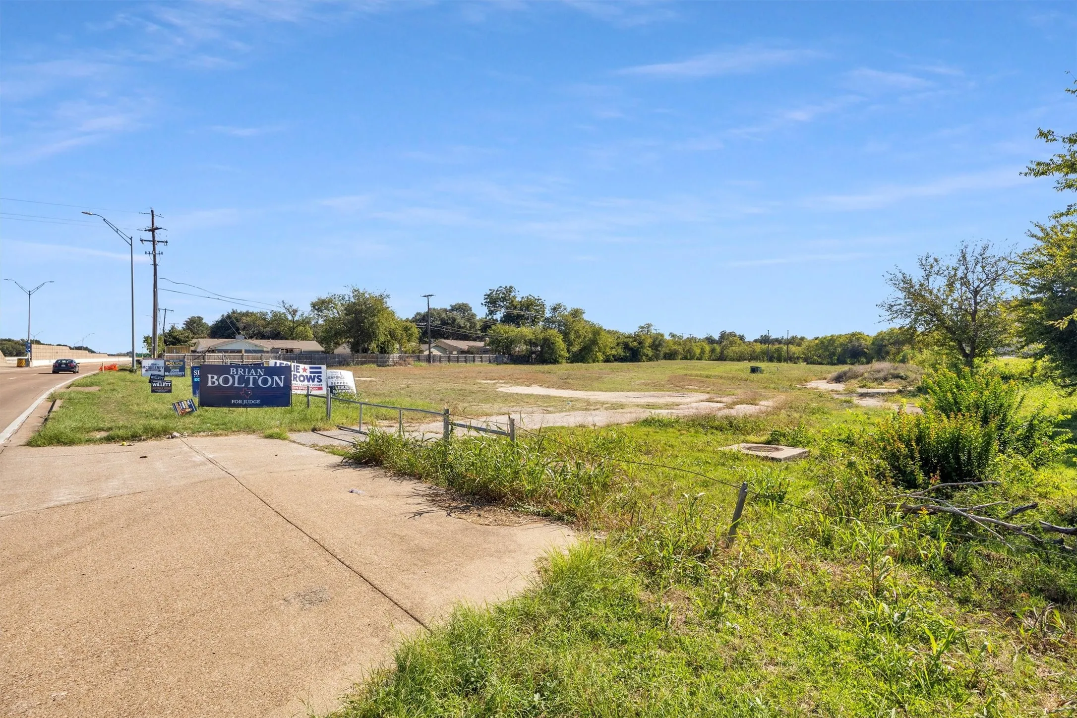 Vacant land parcel featuring level topography, mature trees, and direct street access