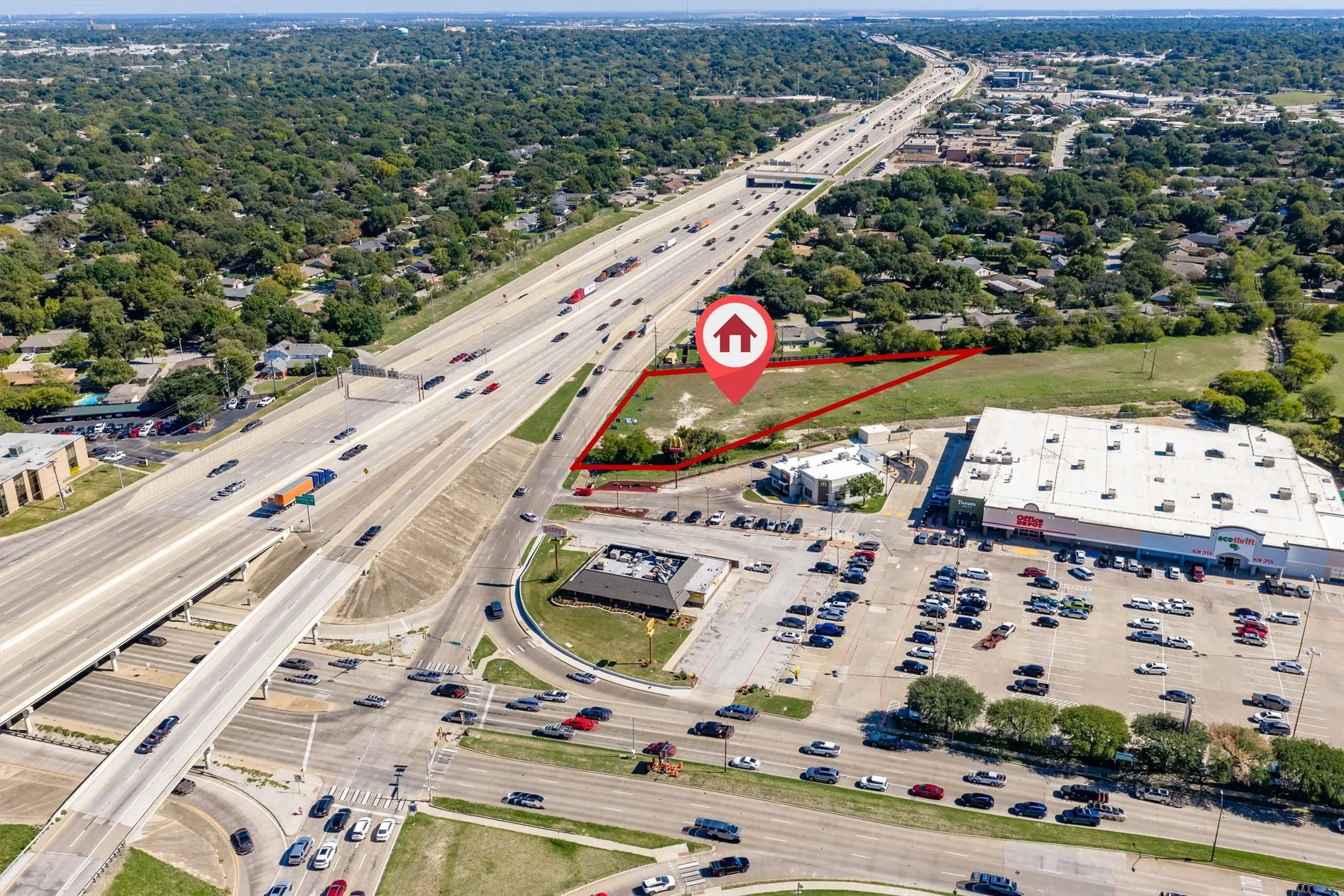 Expansive corner parcel featuring open land, mature trees, and direct exposure to major thoroughfares
