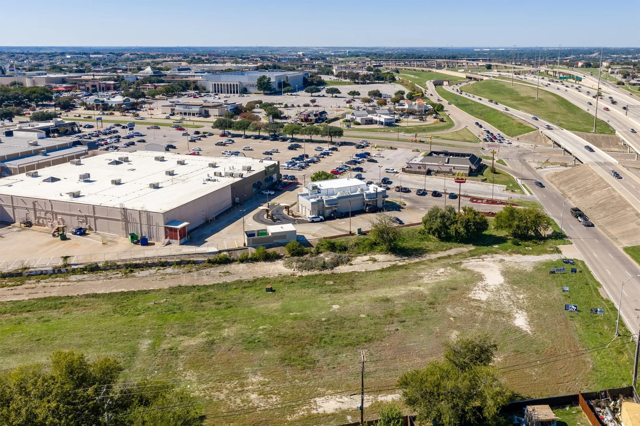 Undeveloped land featuring direct frontage to an arterial roadway, proximity to commercial centers, and open grass terrain