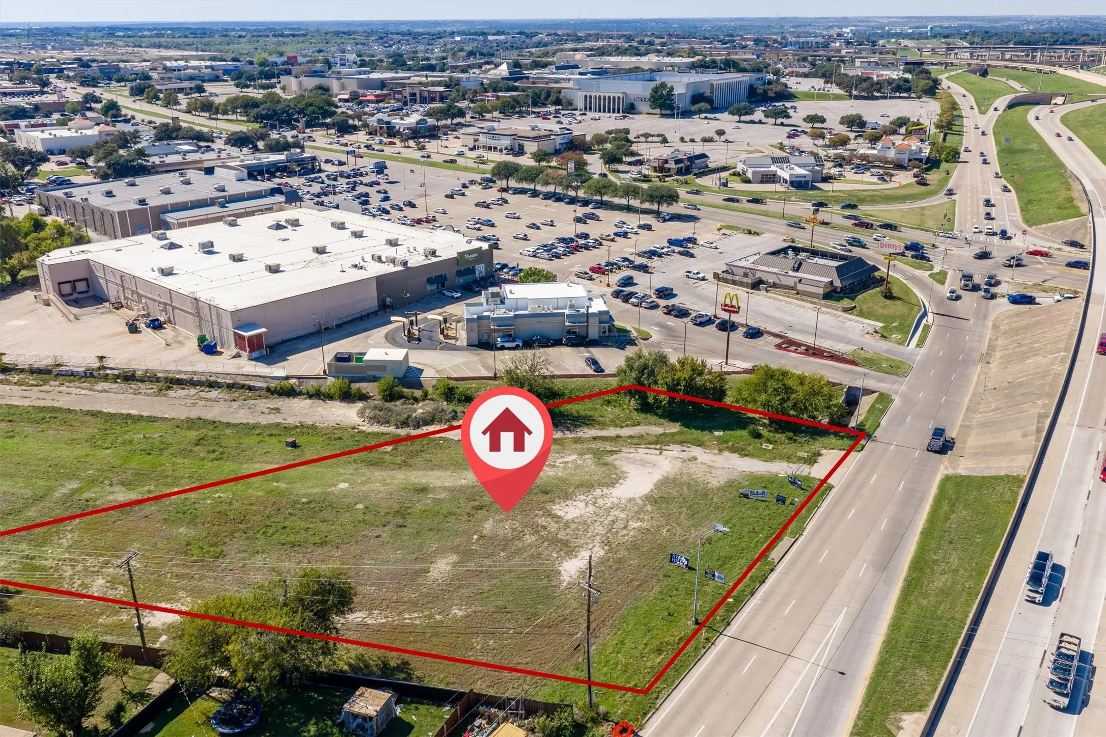 Expansive open land parcel featuring direct highway frontage, clear terrain, and utility pole infrastructure