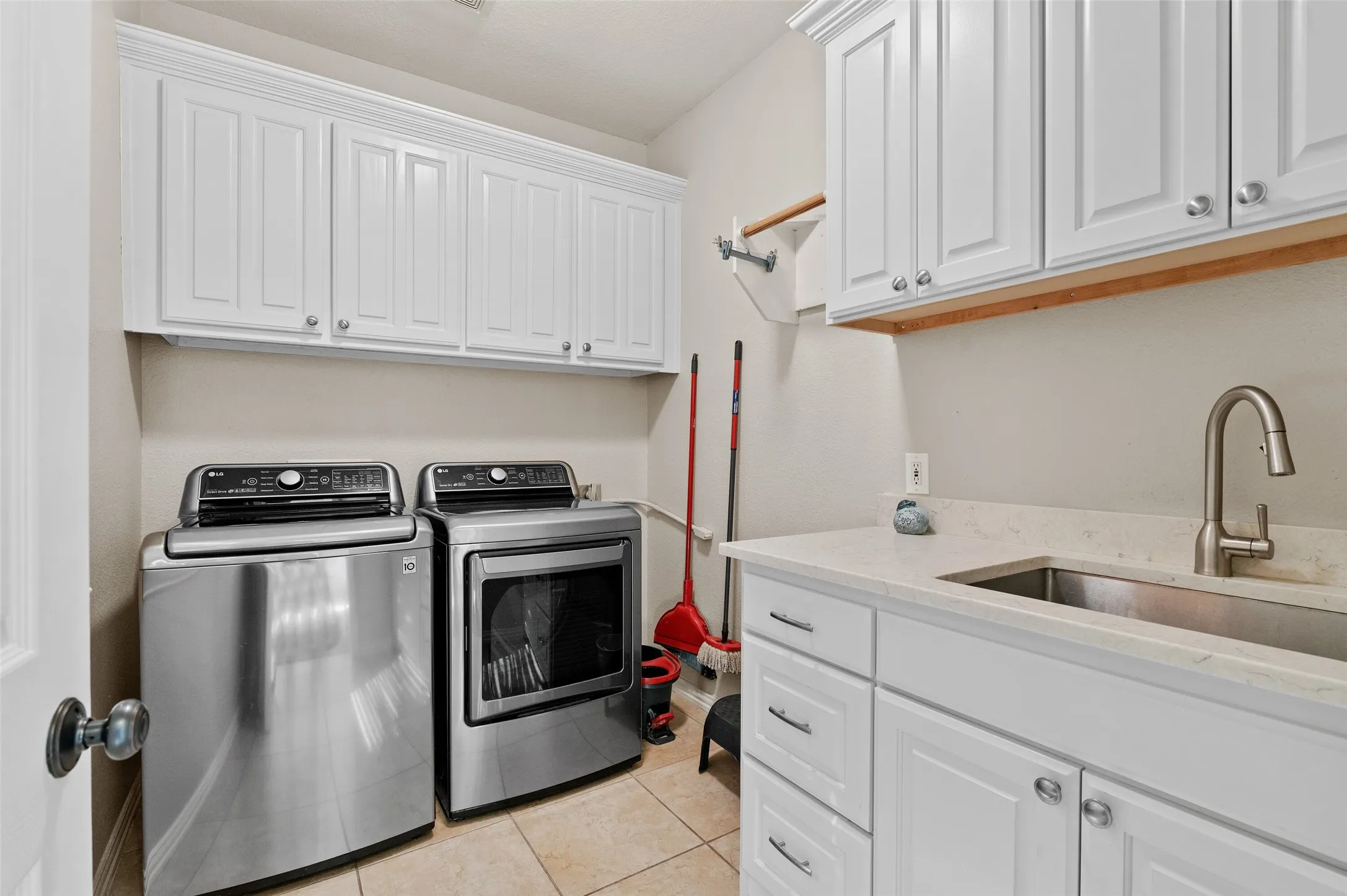 Utility room with sink, folding area and lots of cabinets!