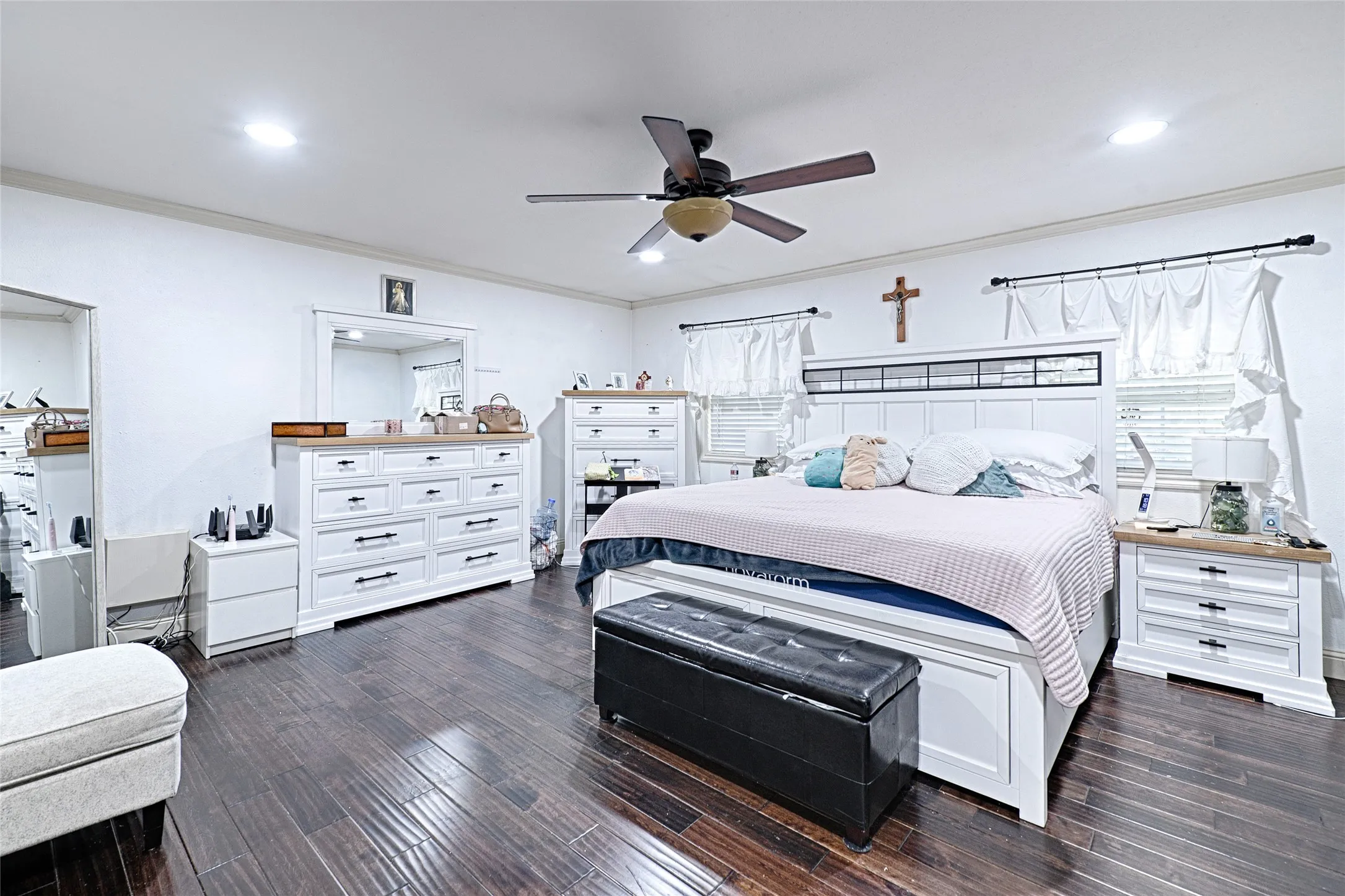 Ceiling fan, recessed lighting, and two windows.