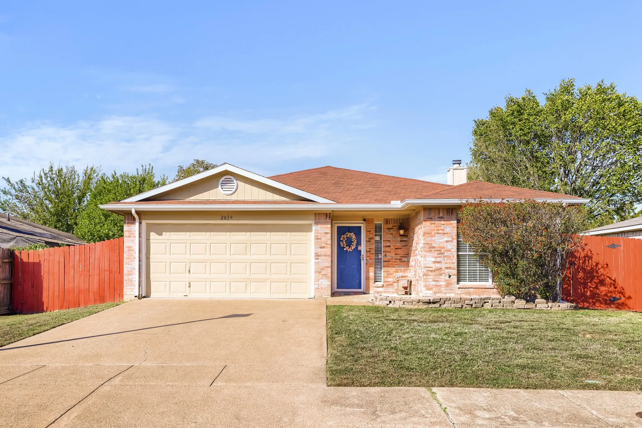 Single-story residence featuring a brick and siding exterior, attached two-car garage, concrete driveway, and a front landscape with a stone border
