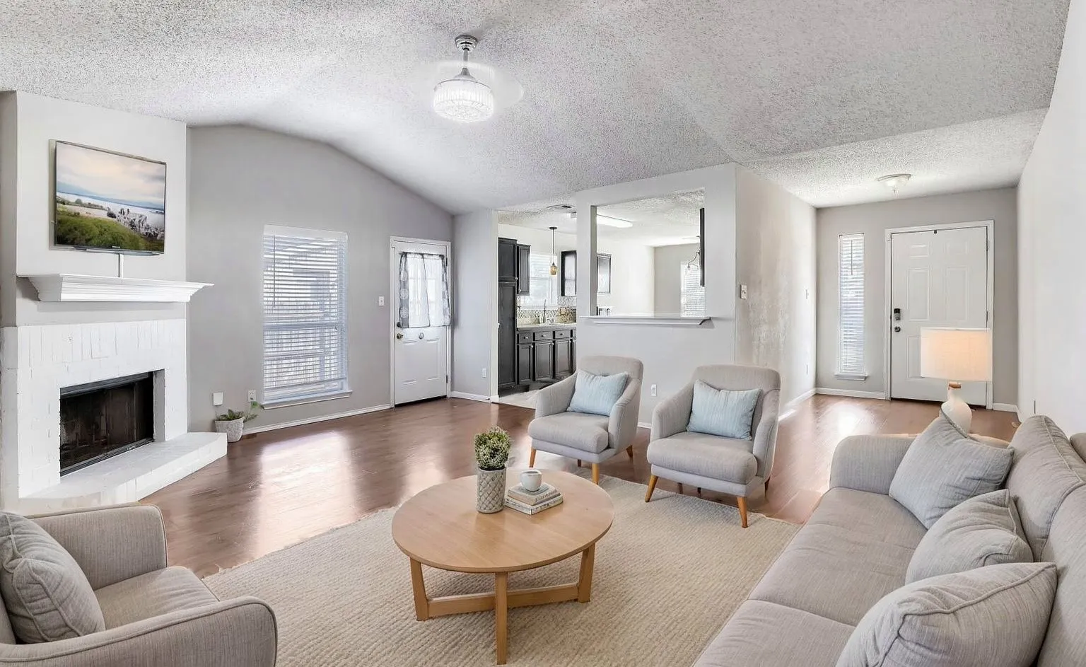 Virtually Staged -Vaulted ceilings, painted brick fireplace with mantel, and wood-finish flooring