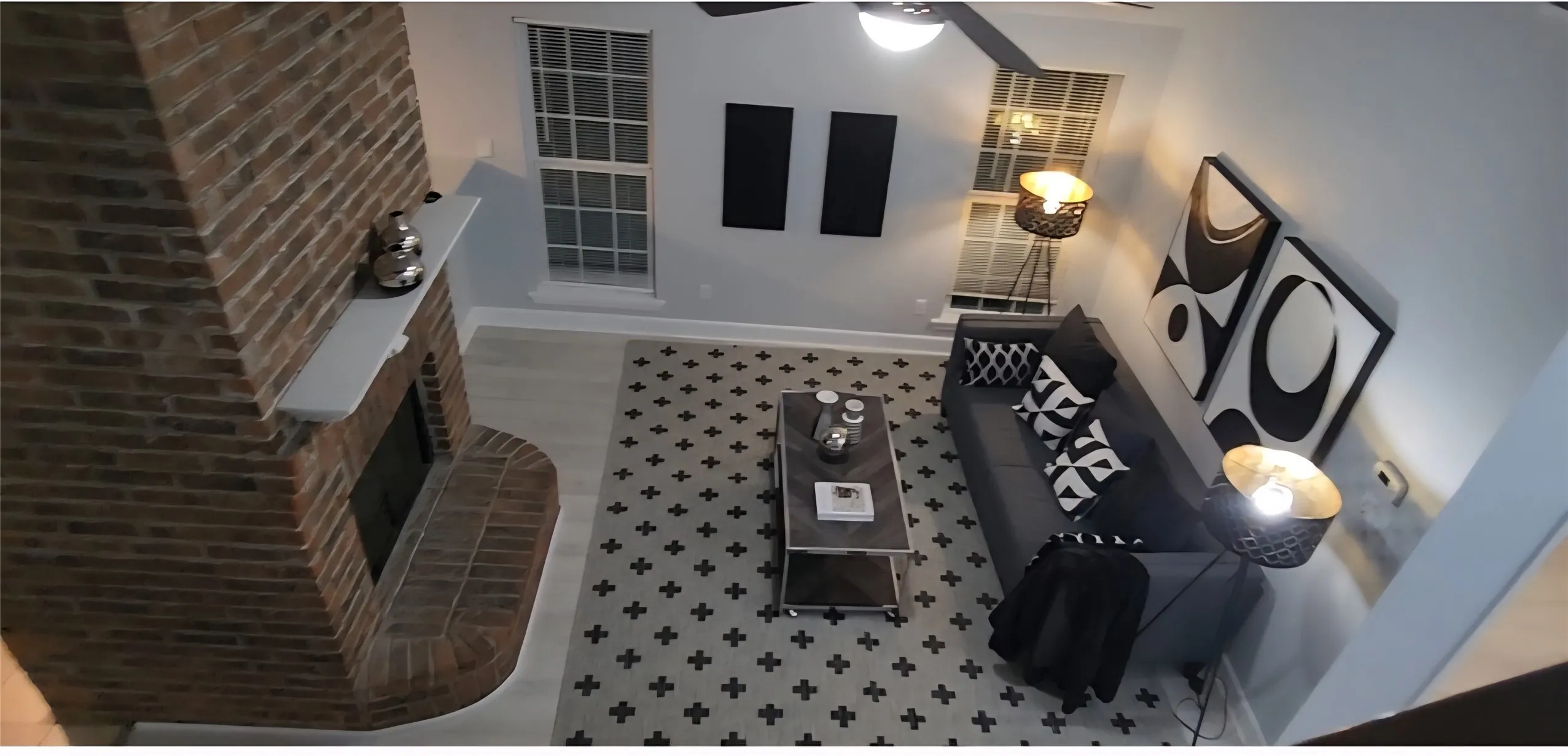 Full-height masonry fireplace with an extended hearth and mantel, neutral wood-finish flooring, and multi-pane windows