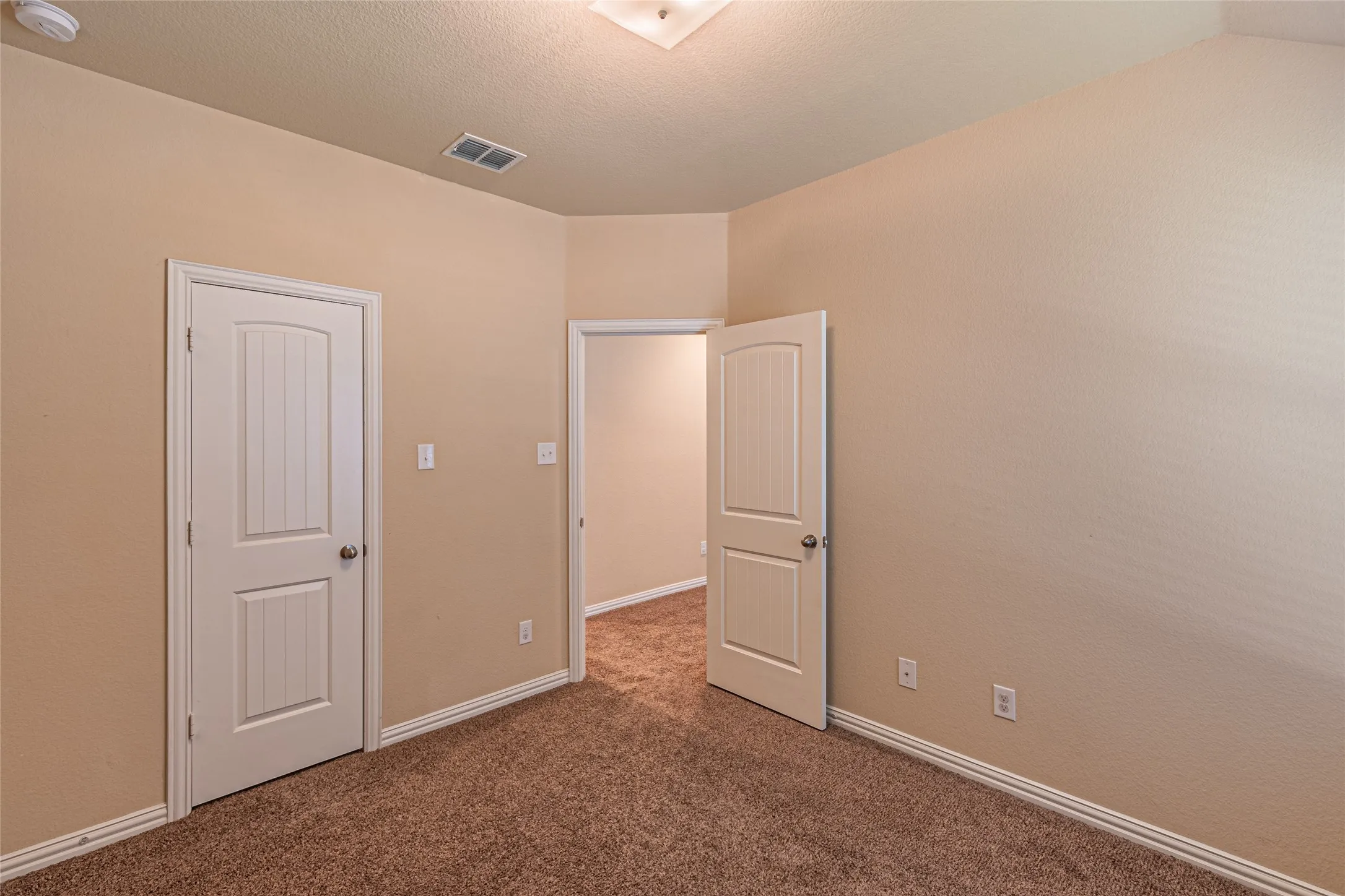 Neutral-toned walls, high ceilings, plush wall-to-wall carpeting, and two-panel interior doors with brushed nickel hardware