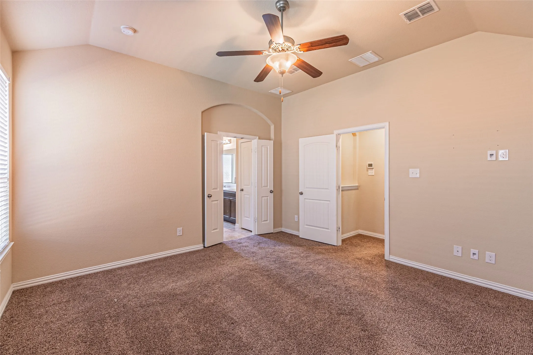 Vaulted ceilings, carpeted flooring, and a ceiling fan with integrated light fixture