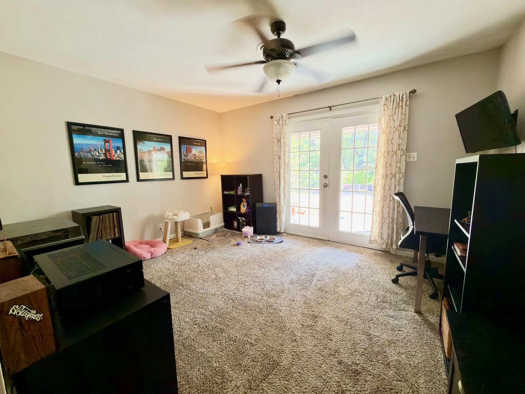 11x13 Neutral-toned interior featuring wall-to-wall carpeting, a ceiling fan with light fixture, and double glass-paned doors