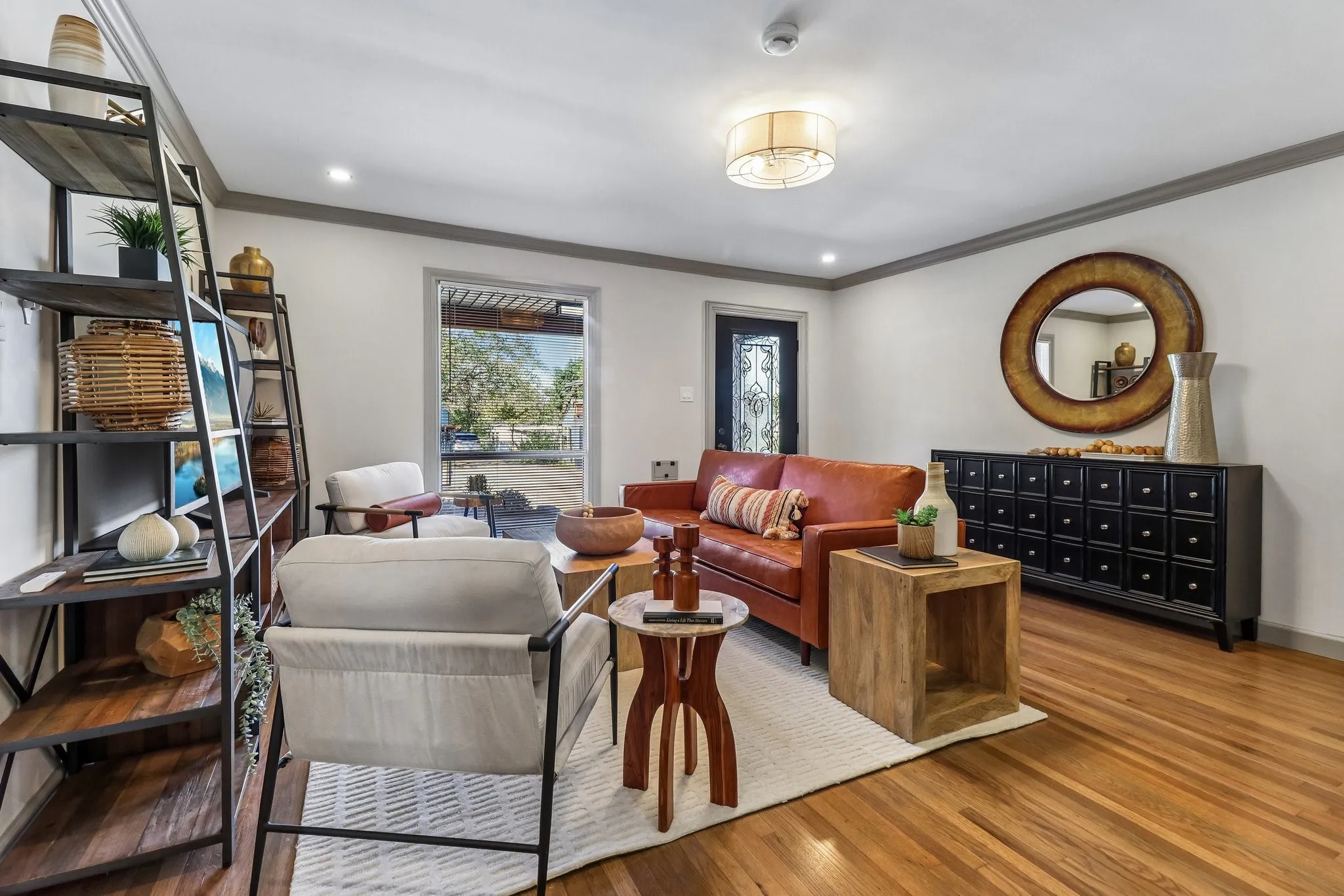 Hardwood flooring, recessed lighting, crown molding, a decorative front entry door, and a built-in shelving unit