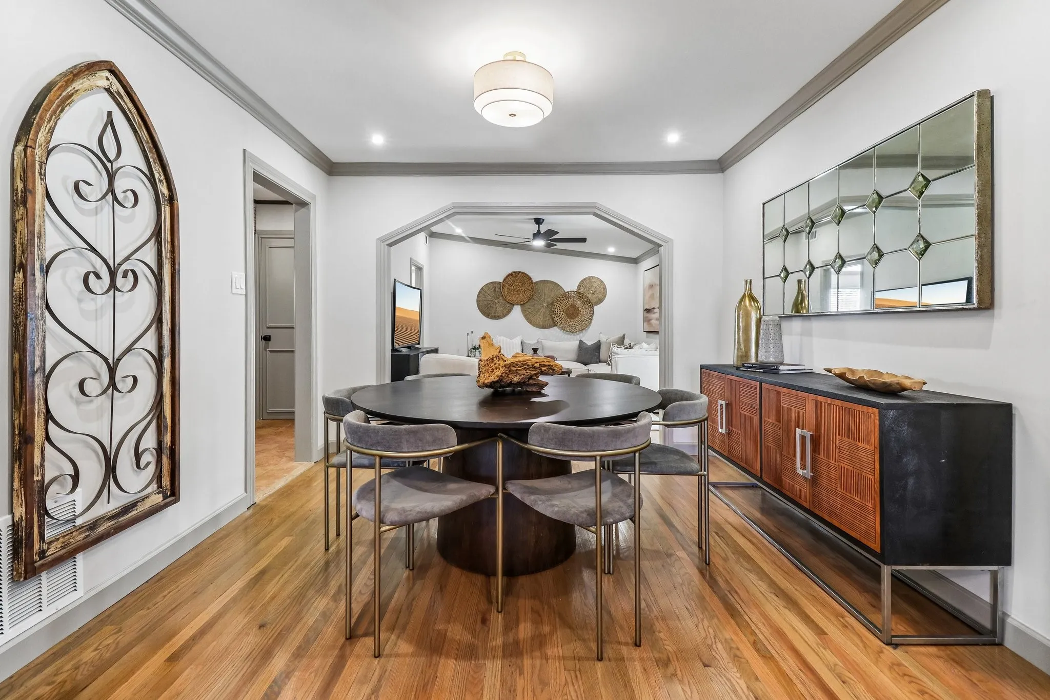 Hardwood flooring, recessed lighting, arched doorway, crown molding, and a built-in sideboard with wood-finish cabinet doors