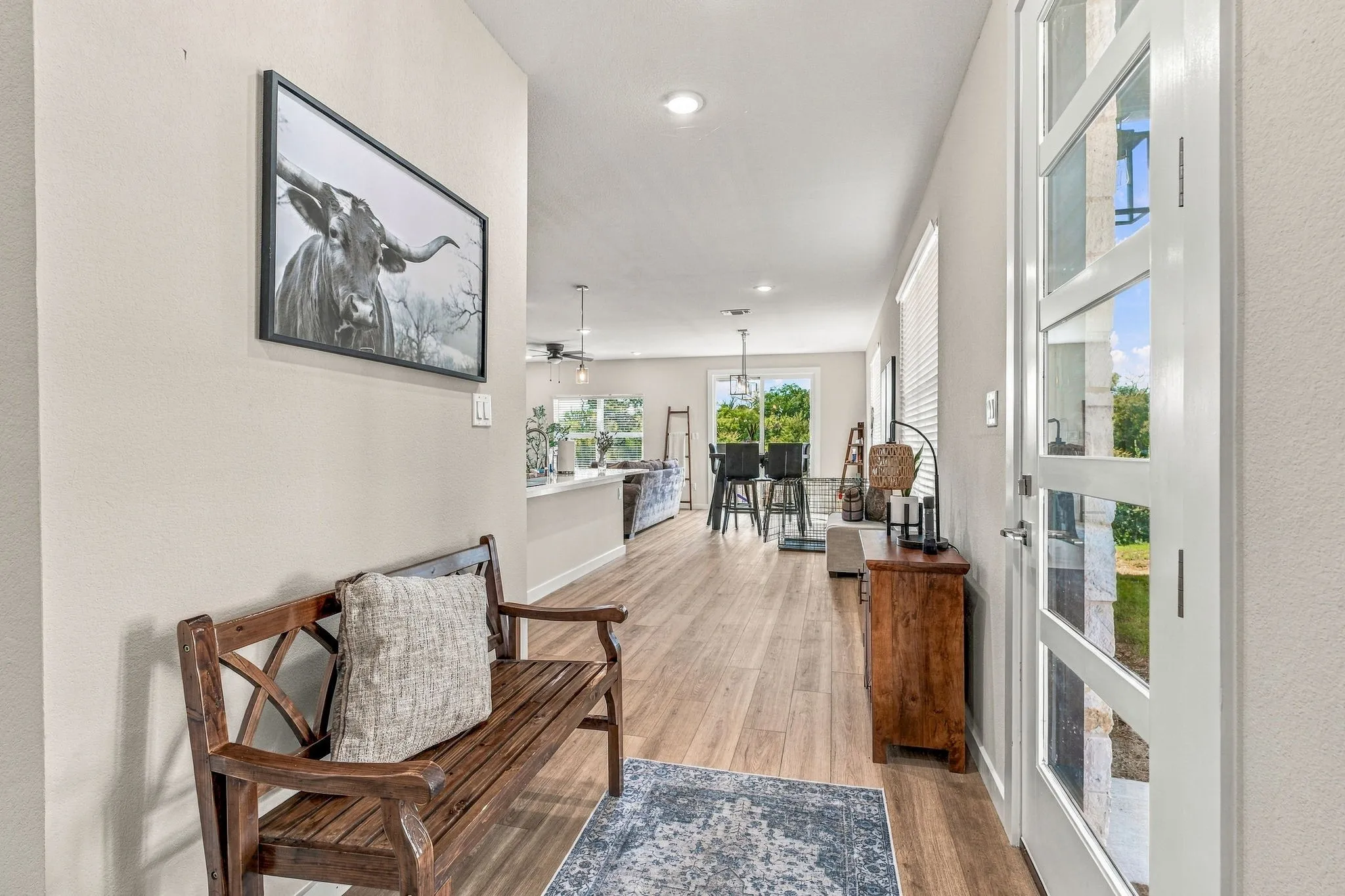 Entryway featuring a white door with horizontal glass panels, neutral wall palette, wood-finish flooring, and recessed ceiling lighting