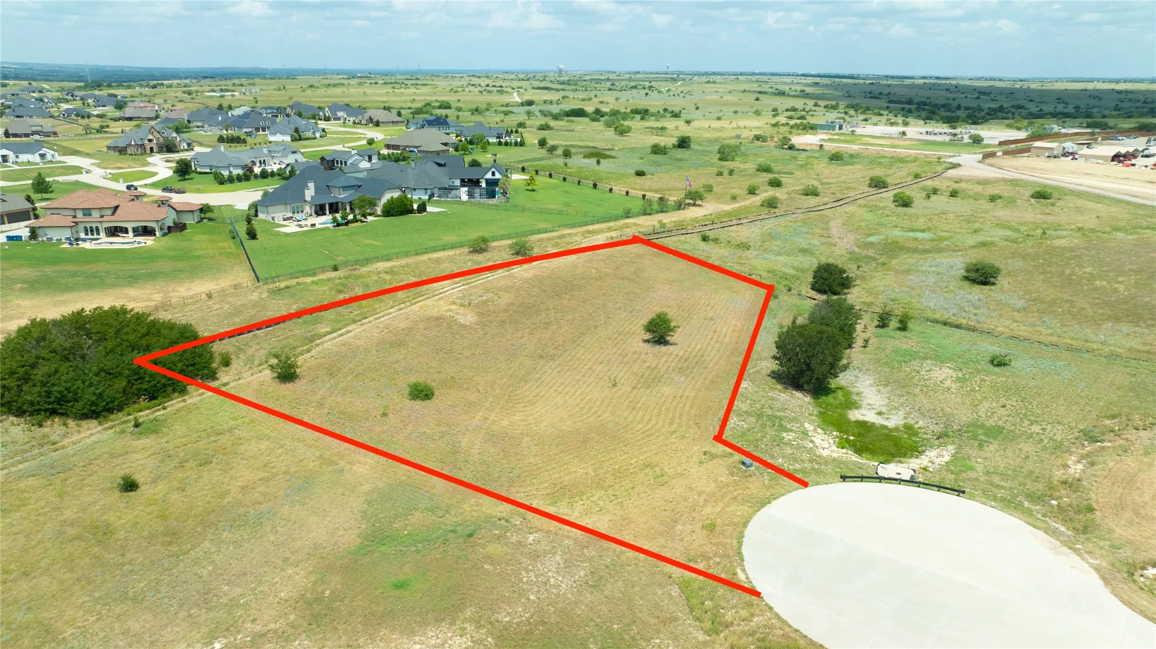 Expansive corner lot featuring open terrain, mature trees, and a concrete cul-de-sac entry point