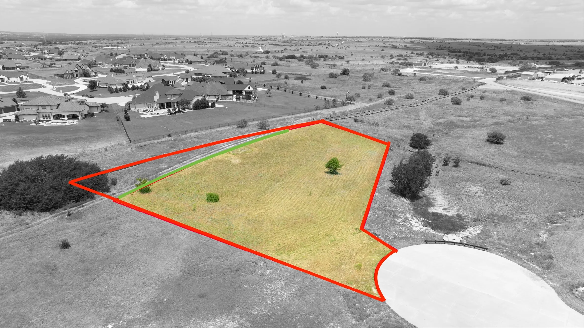 Expansive vacant land lot featuring grass-covered terrain, mature trees, and frontage on a cul-de-sac