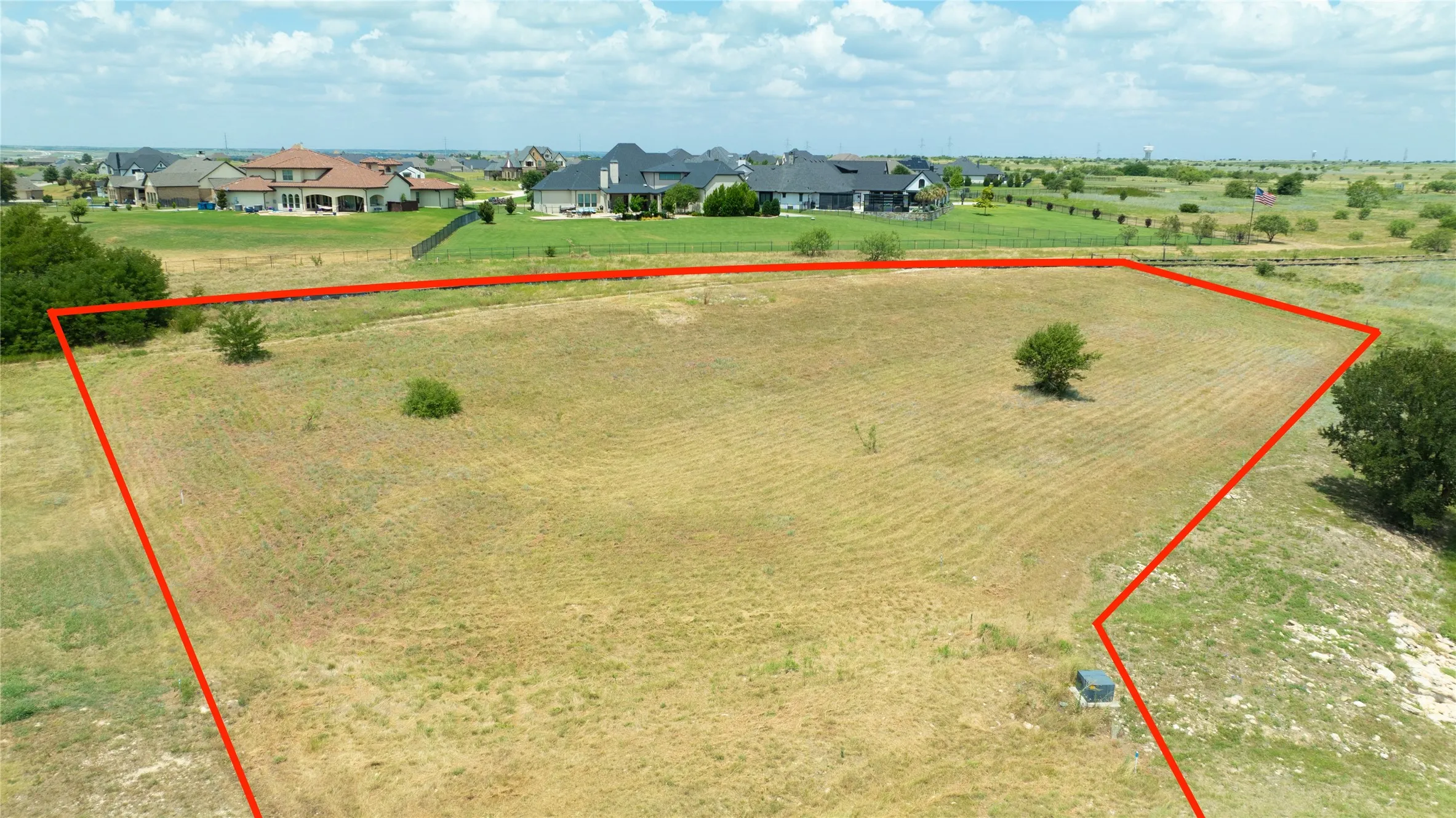 Expansive parcel of land featuring open terrain, scattered mature trees, and clear boundary lines