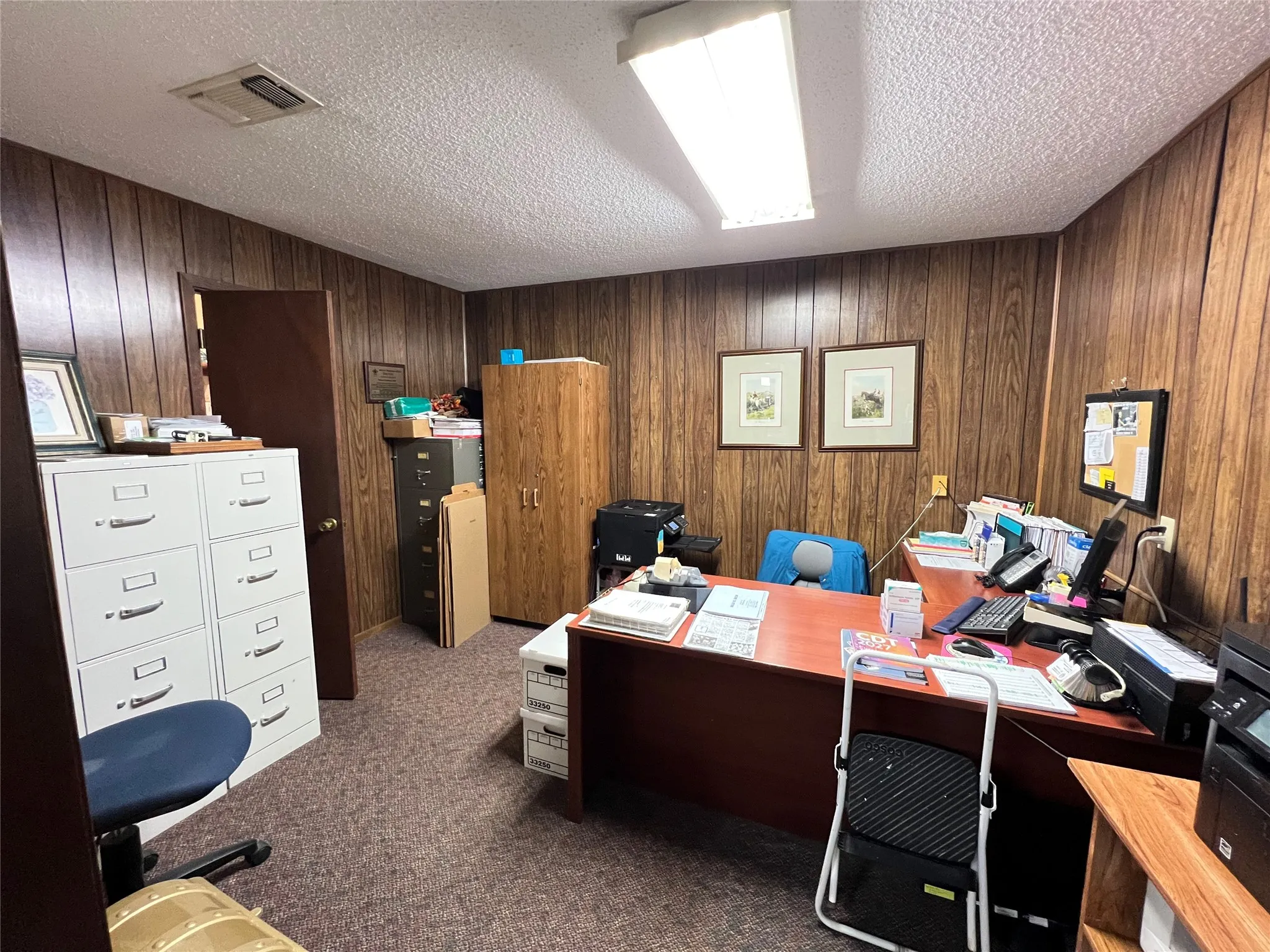 Interior room featuring wood-paneled walls, carpeted flooring, and a flush-mount rectangular light fixture