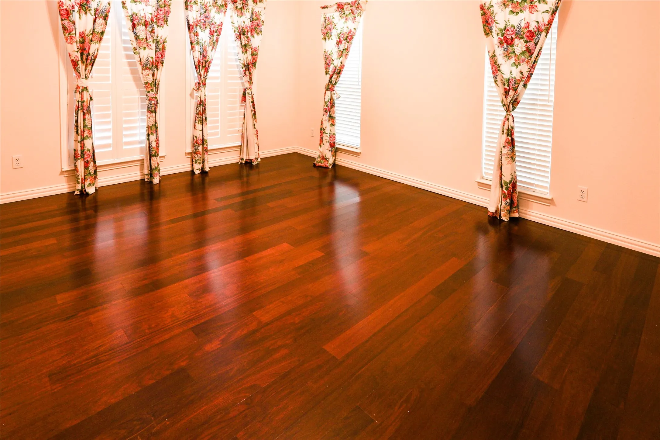 Polished wood-finish flooring, plantation-style window shutters, and multi-pane windows