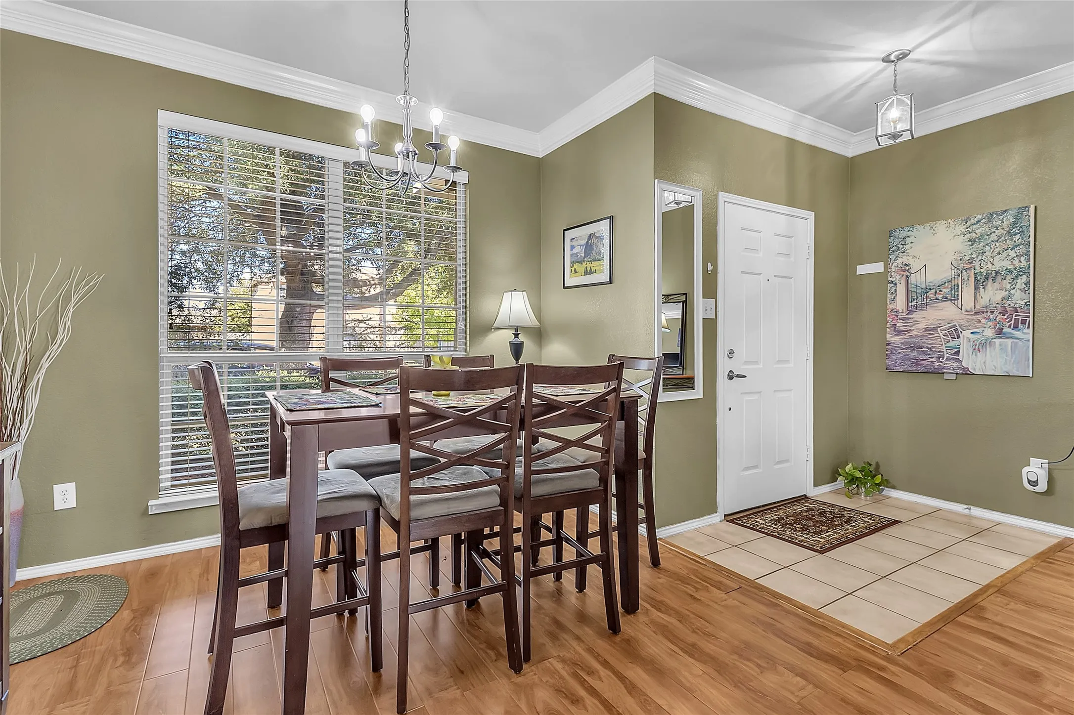 Entry and dining area with tile foyer, manufactured-wood floors, and chandelier