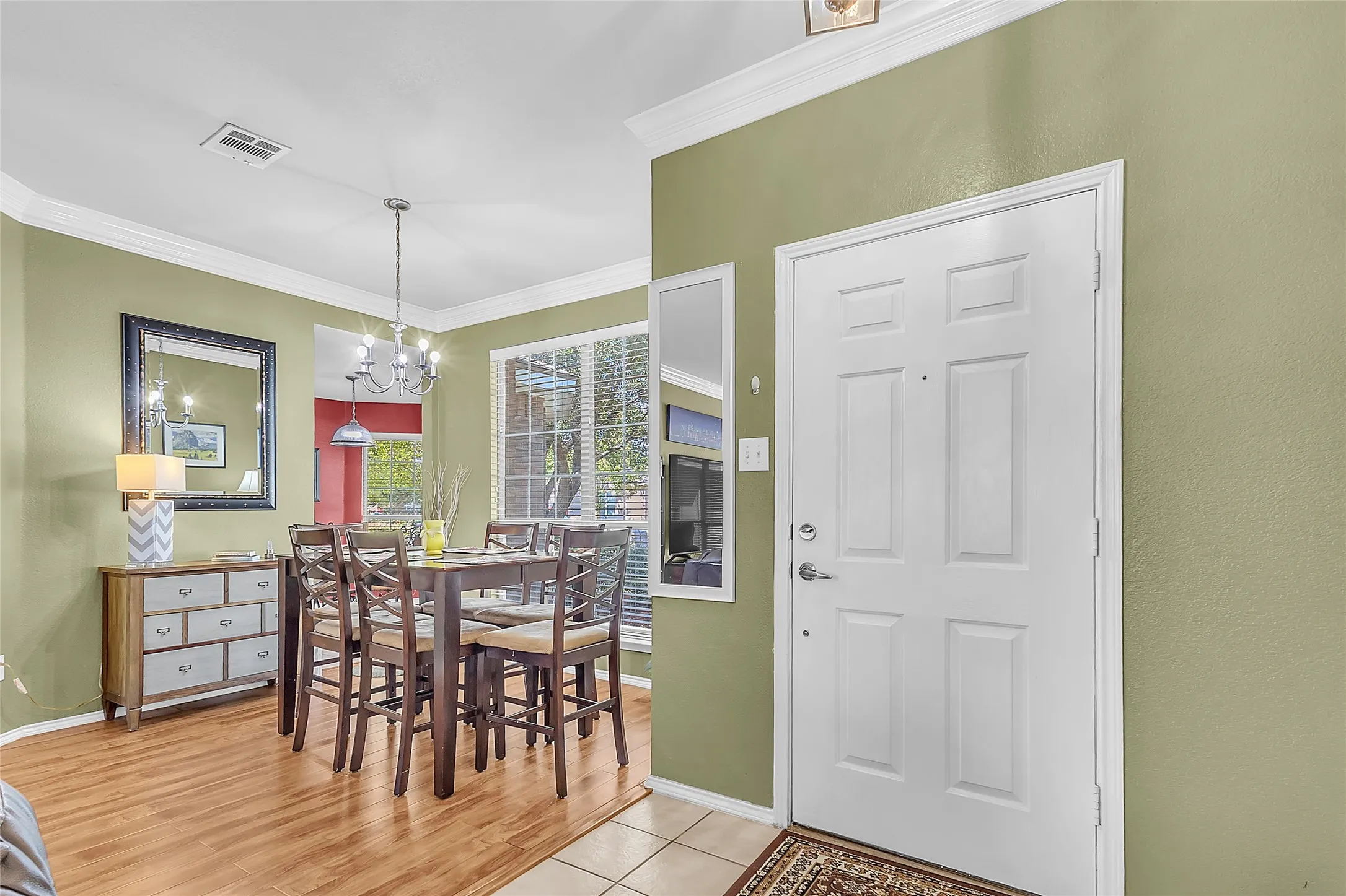 Foyer and formal dining with crown molding and chandelier — Denton