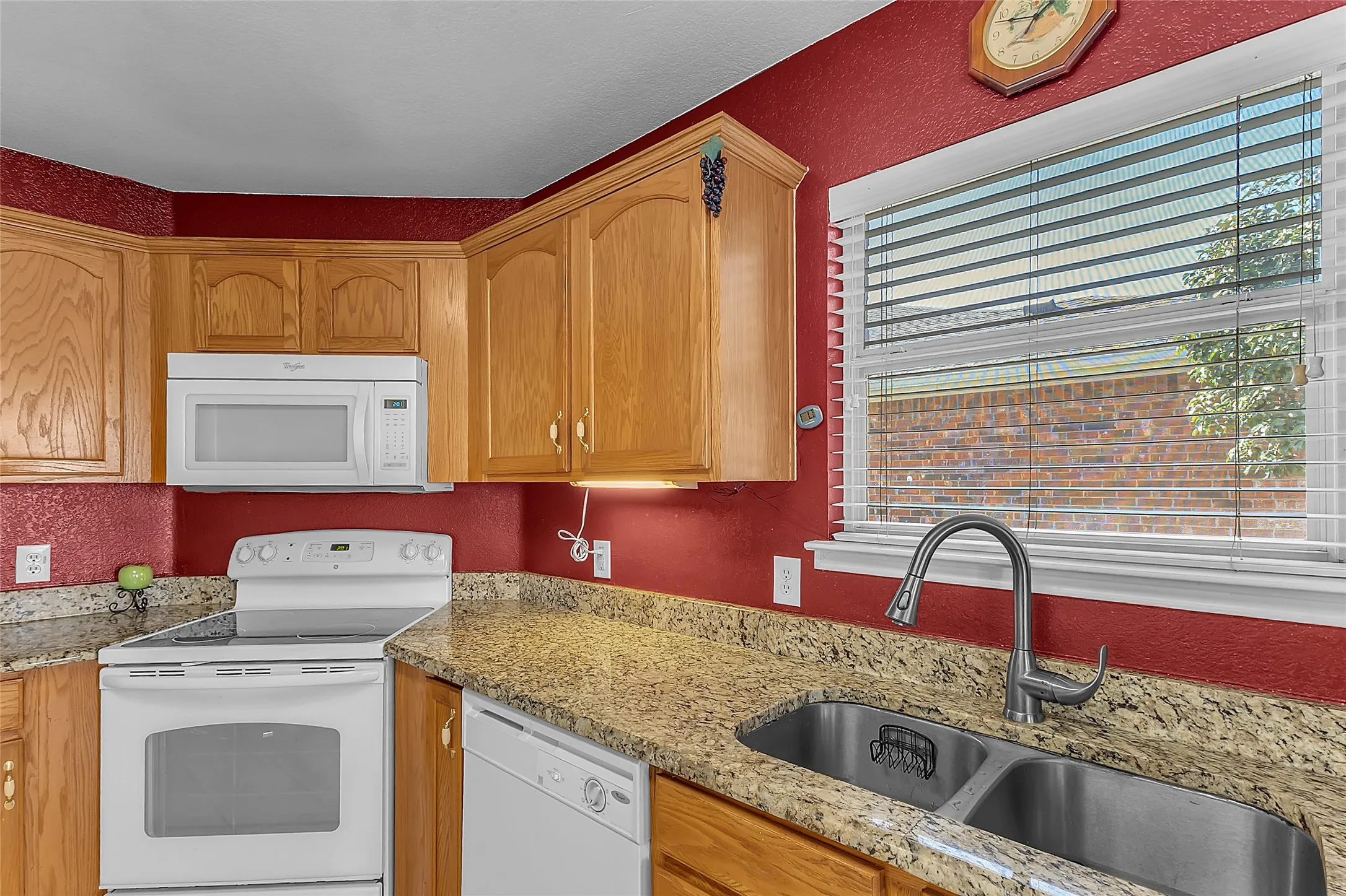 Kitchen: oak cabinets, granite counters, white range and microwave