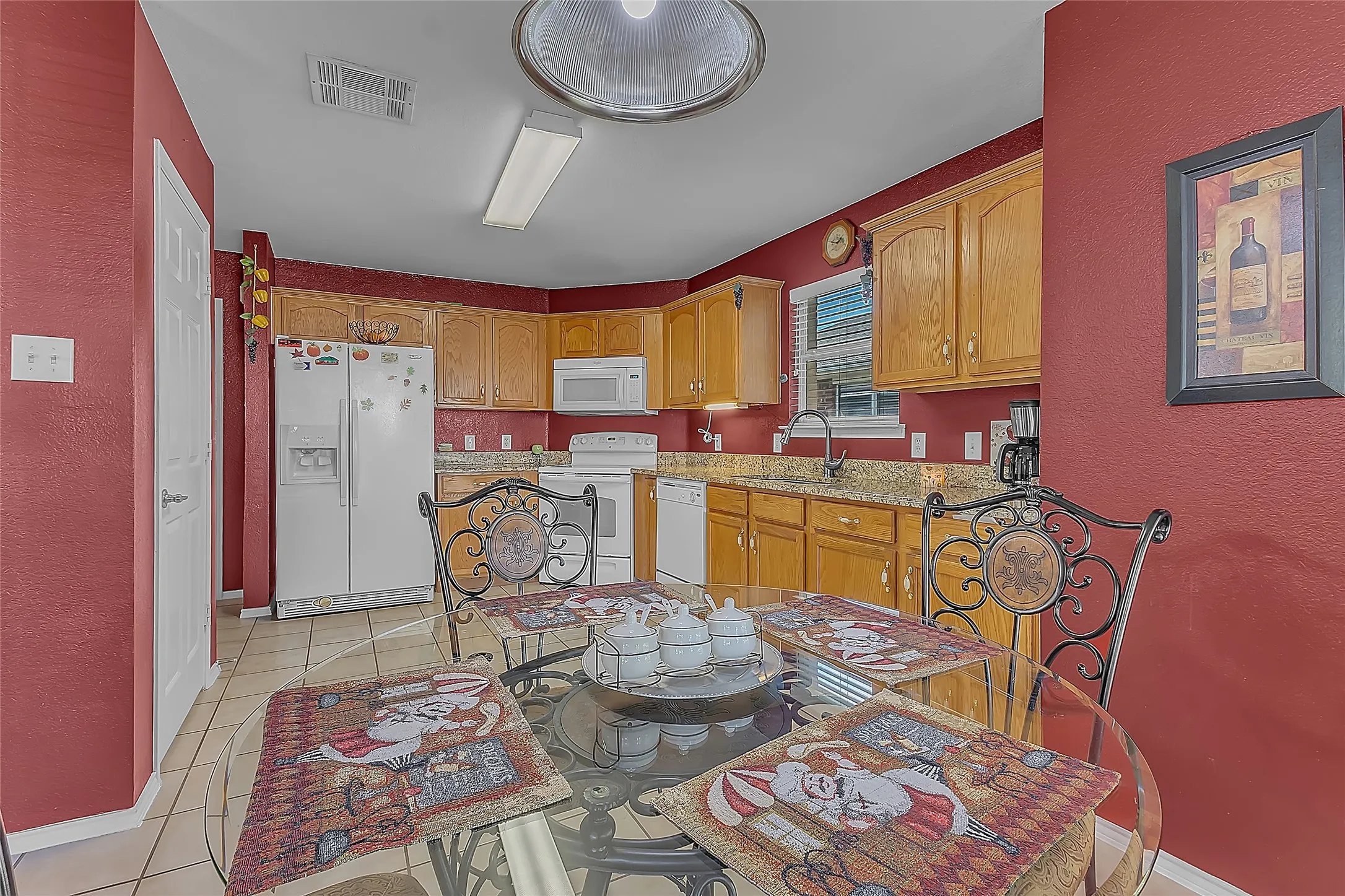 Kitchen and breakfast nook with red walls and granite counters