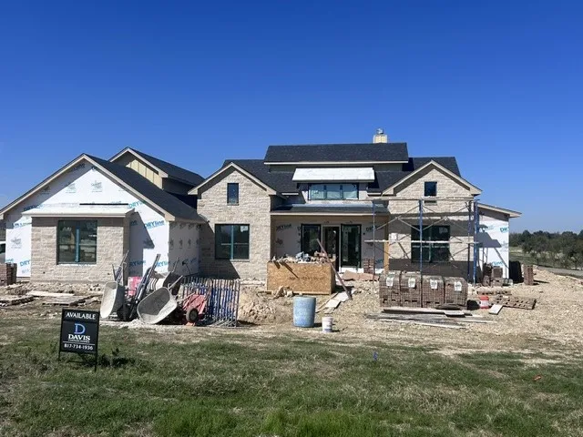 Multi-gabled exterior featuring light-toned stone masonry, dark shingled roofing, and fixed-pane windows