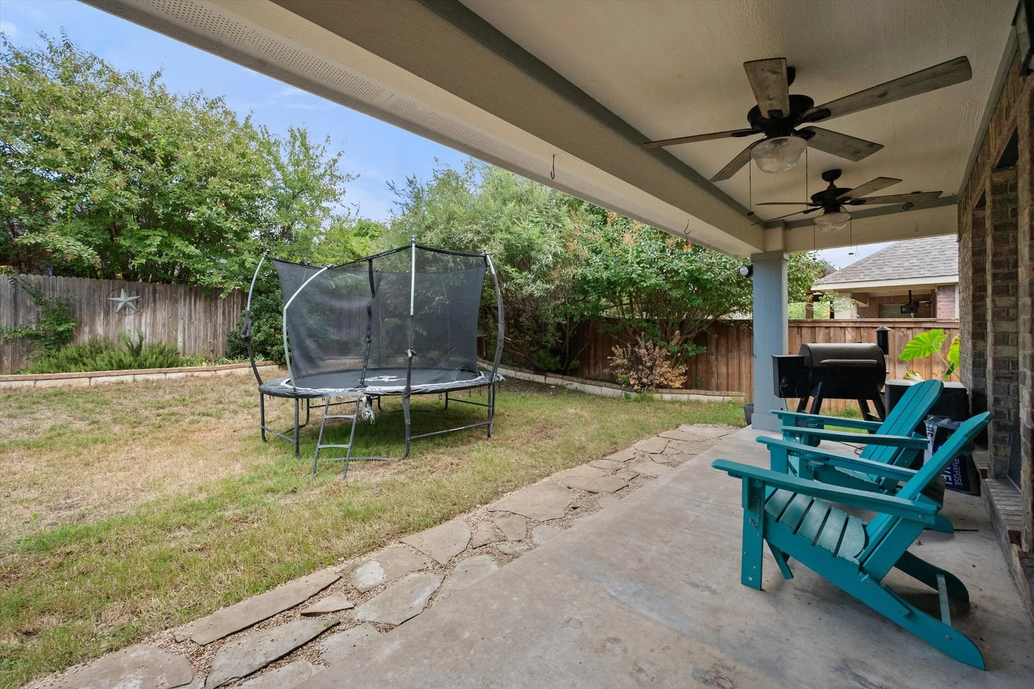 Beautiful covered patio in backyard with ceiling fans.