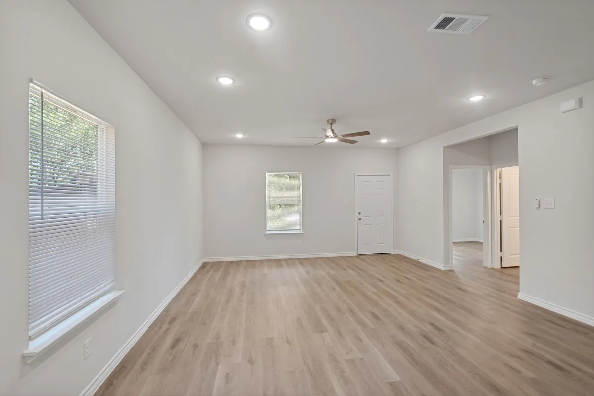 Neutral-toned interior featuring wood-finish flooring, recessed lighting, and a ceiling fan