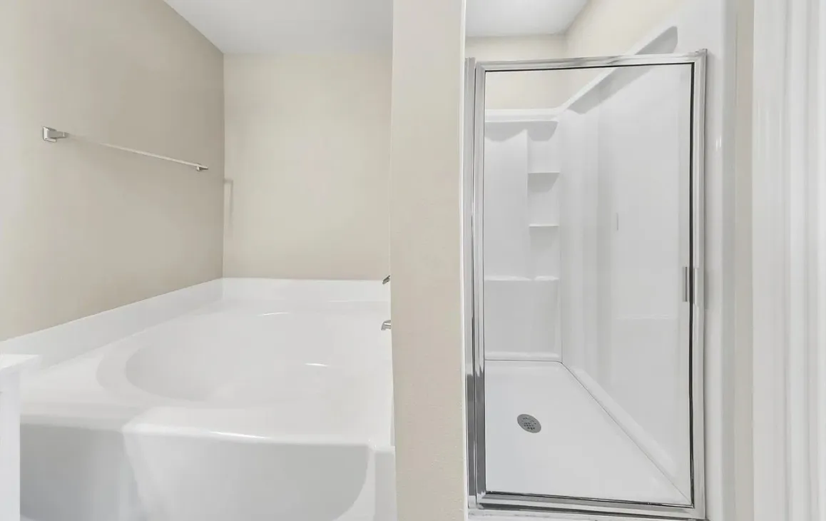 Deep soaking tub featuring an integrated surround and a separate walk-in shower with a glass enclosure and built-in shelving