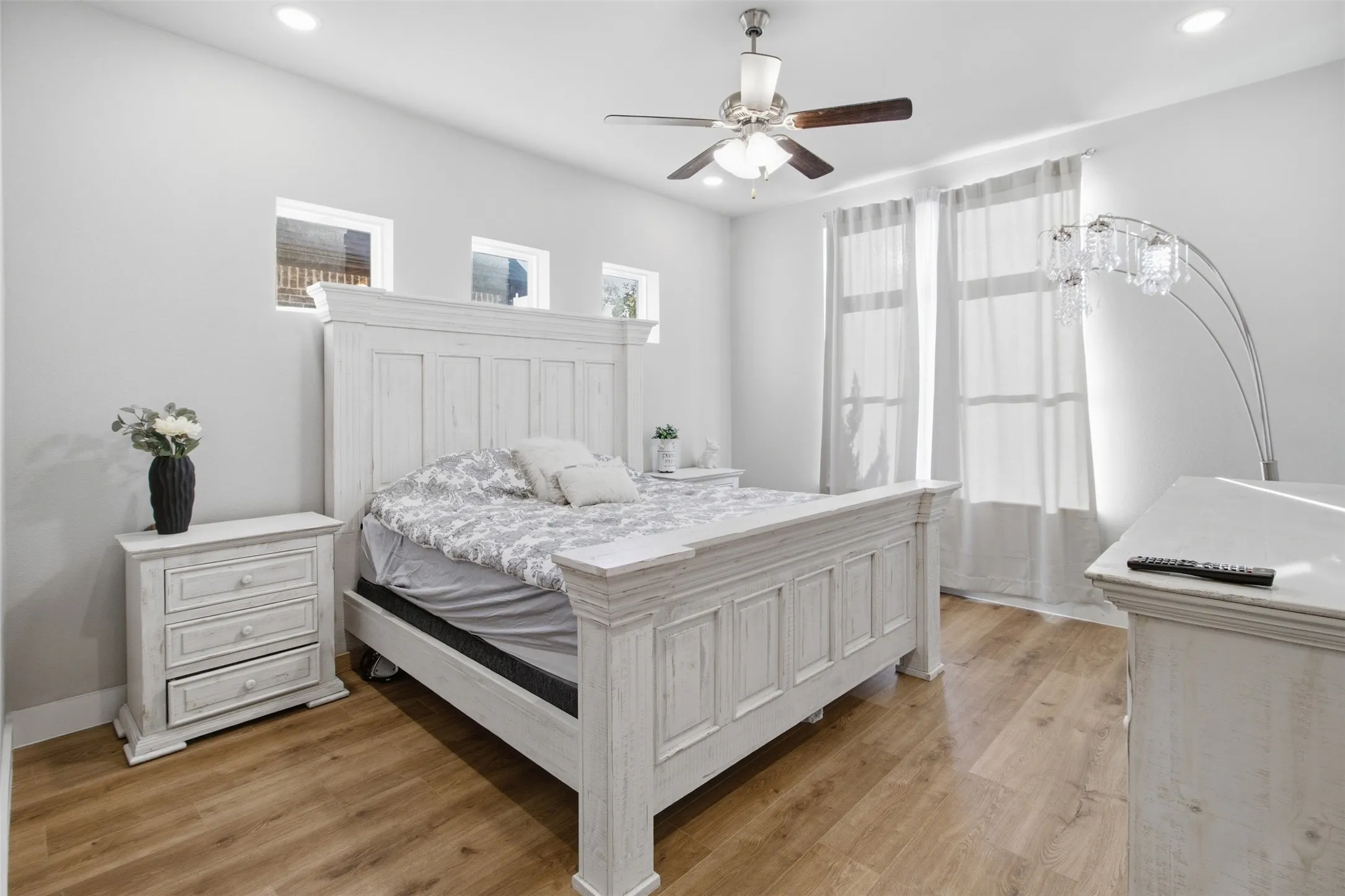 Wood-finish flooring, recessed lighting, ceiling fan with light kit, and multiple windows providing natural light