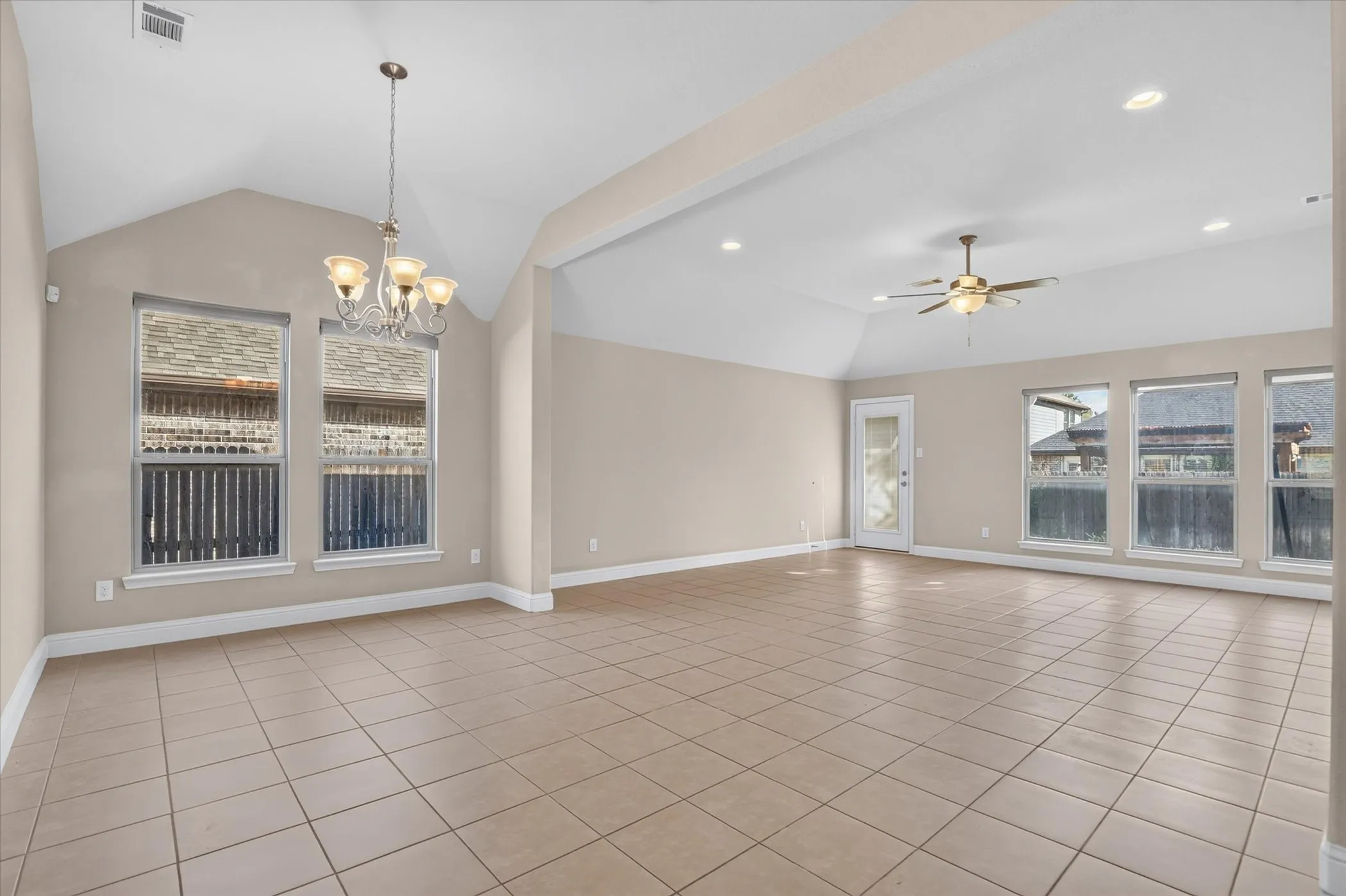 Vaulted ceilings featuring recessed lighting, ceramic tile flooring, a multi-arm chandelier, and a ceiling fan