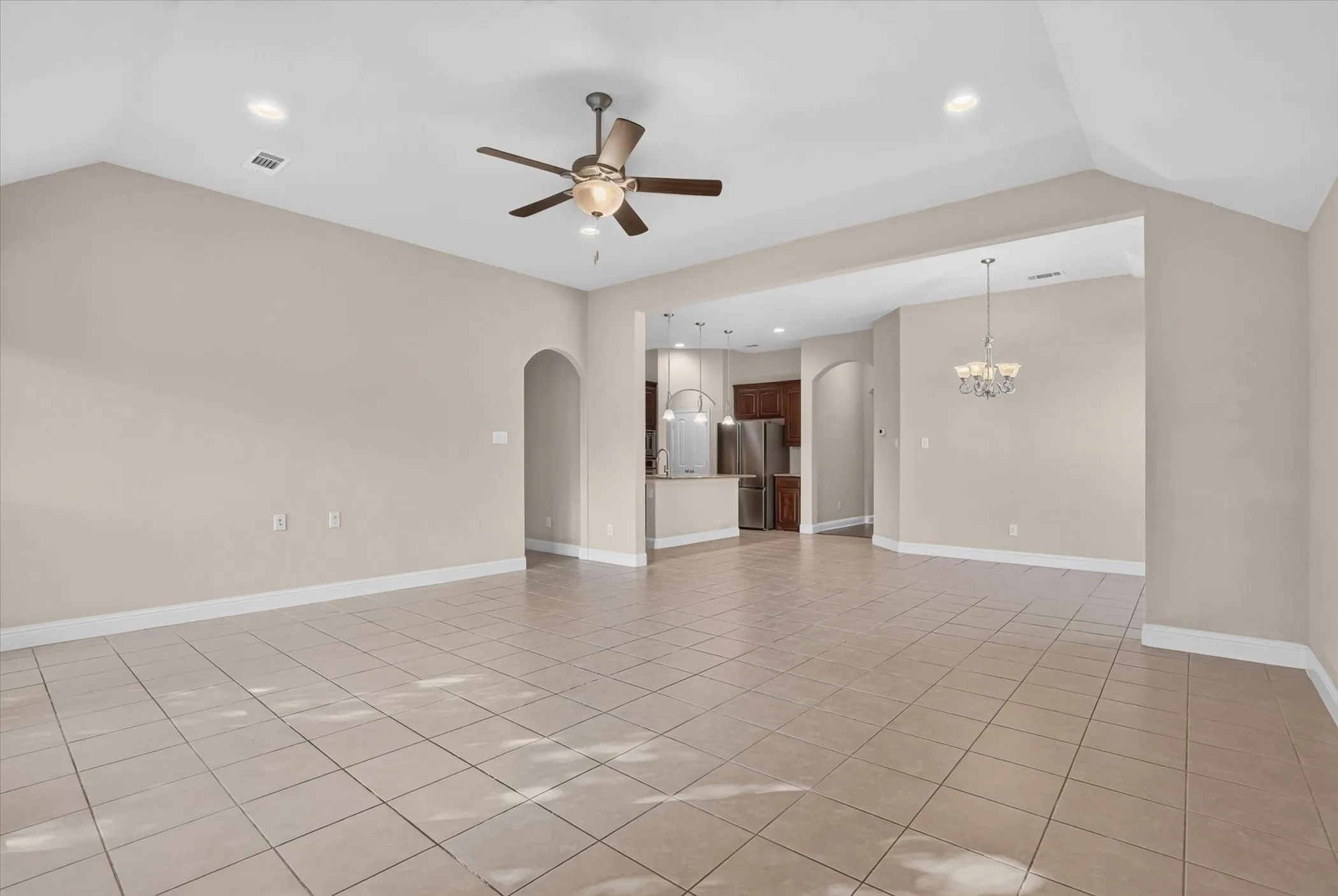 Vaulted ceilings featuring recessed lighting, a ceiling fan, ceramic tile flooring, arched doorways, and a pendant light fixture