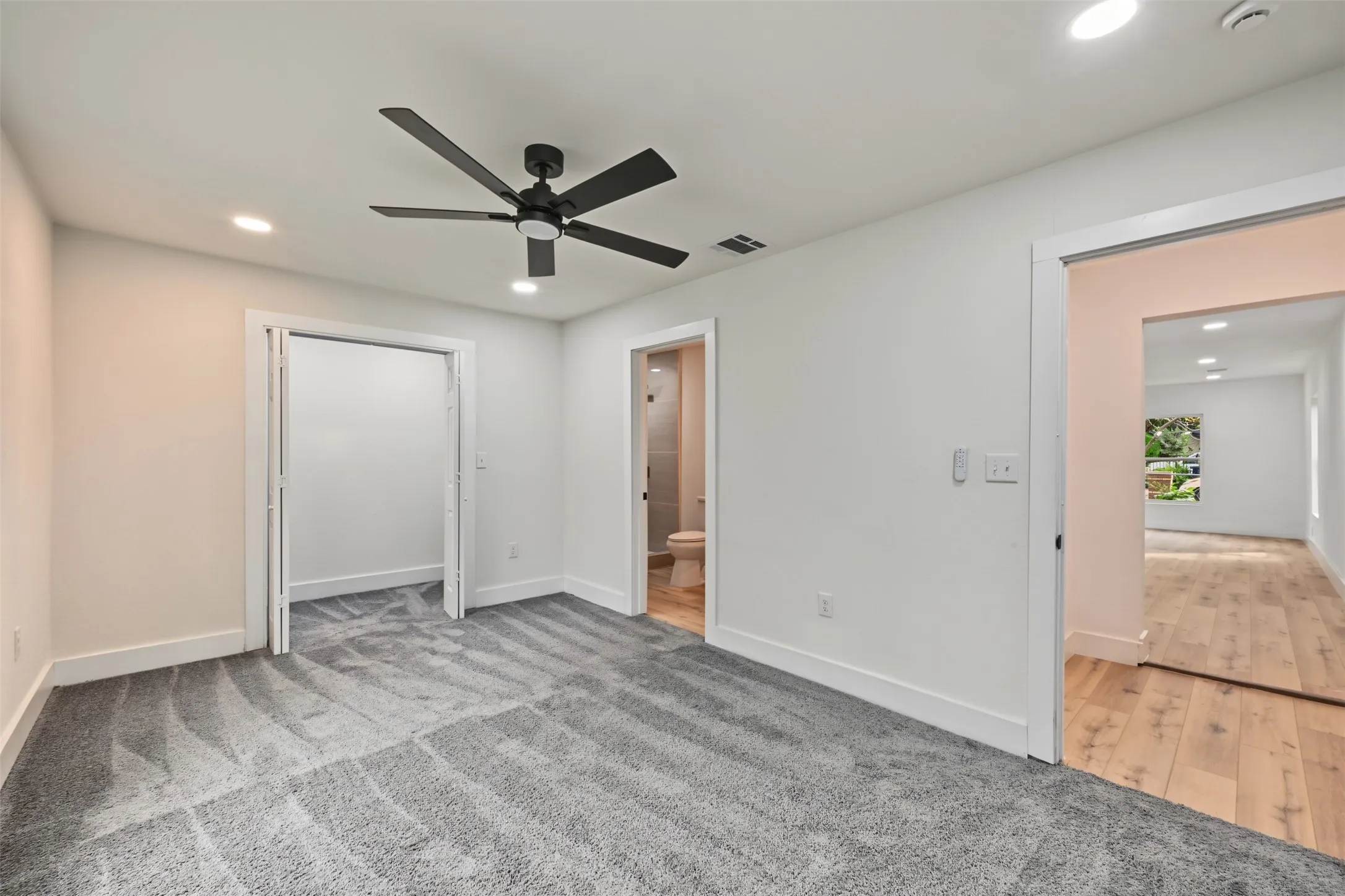 Neutral-toned wall-to-wall carpeting, matte black ceiling fan with integrated lighting, recessed lighting, and wood-finish flooring