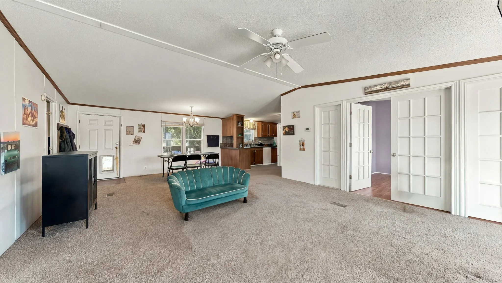 Vaulted ceilings, white multi-pane French doors, and a ceiling fan