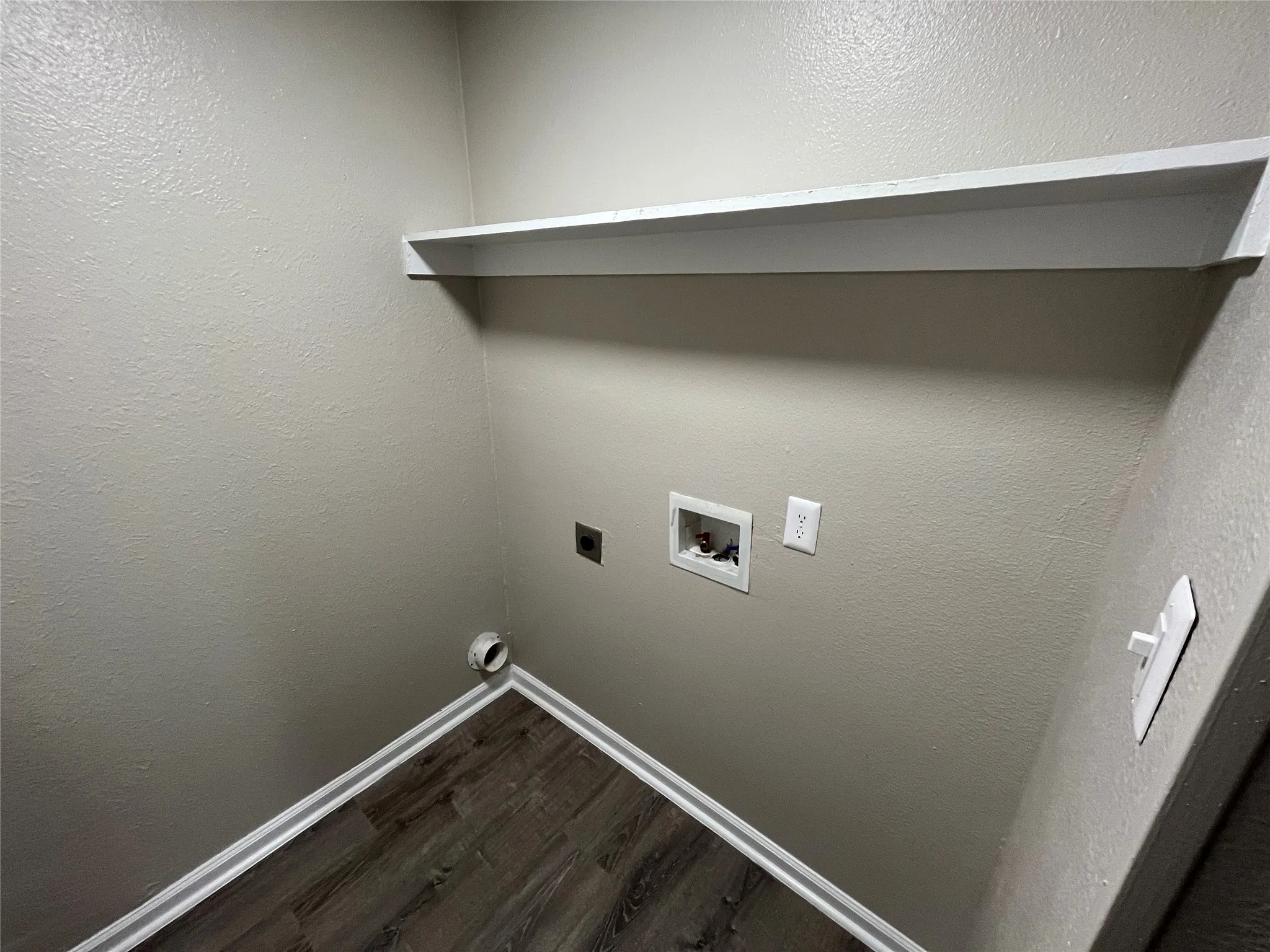 Utility area featuring wood-finish flooring and a built-in floating shelf
