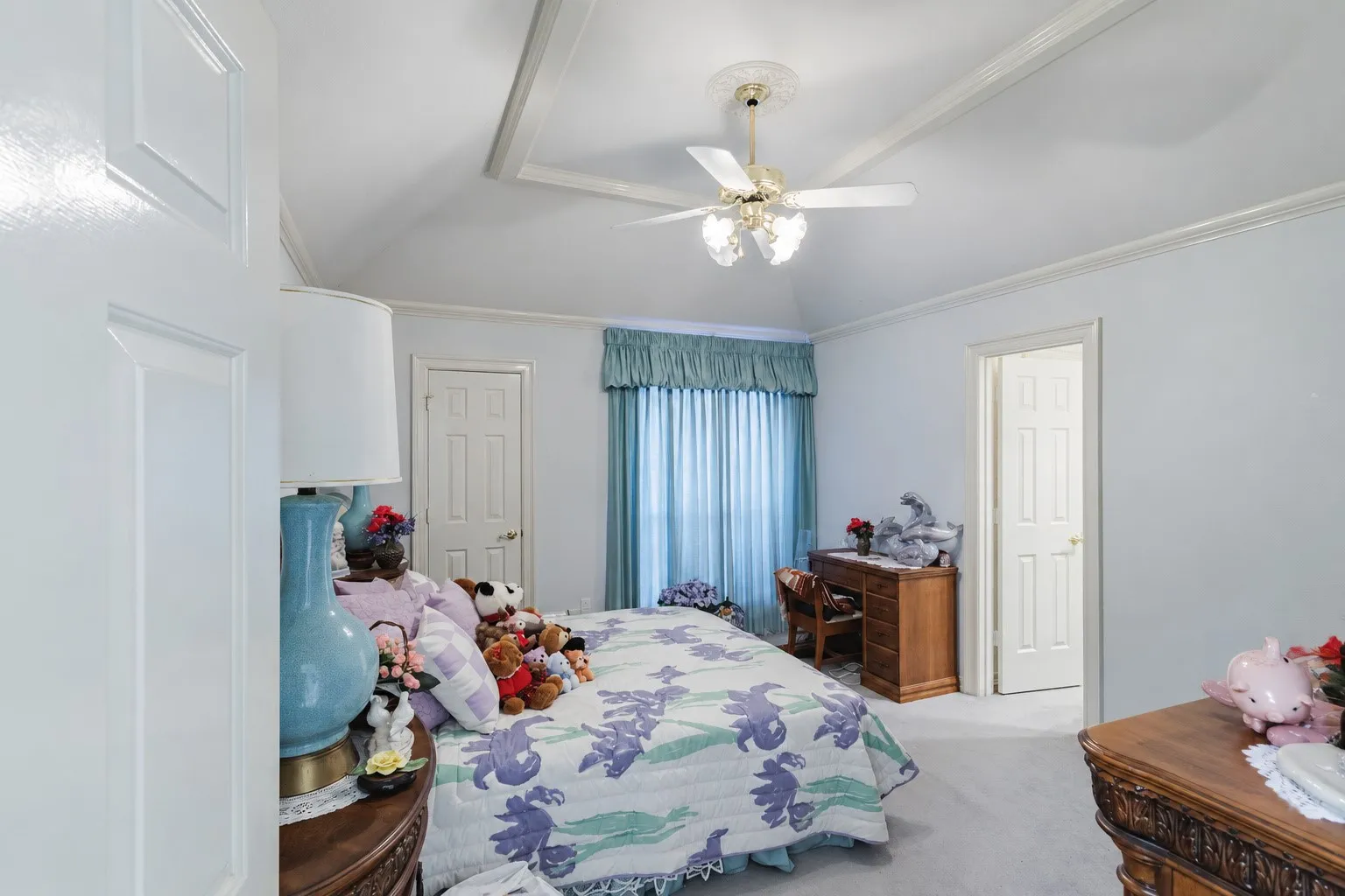 Vaulted ceiling featuring architectural tray detailing and a central ceiling fan with multi-light fixture