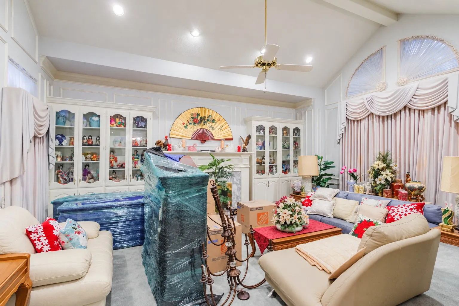 Vaulted ceilings, built-in display cabinetry, stone-surround fireplace, and arched windows
