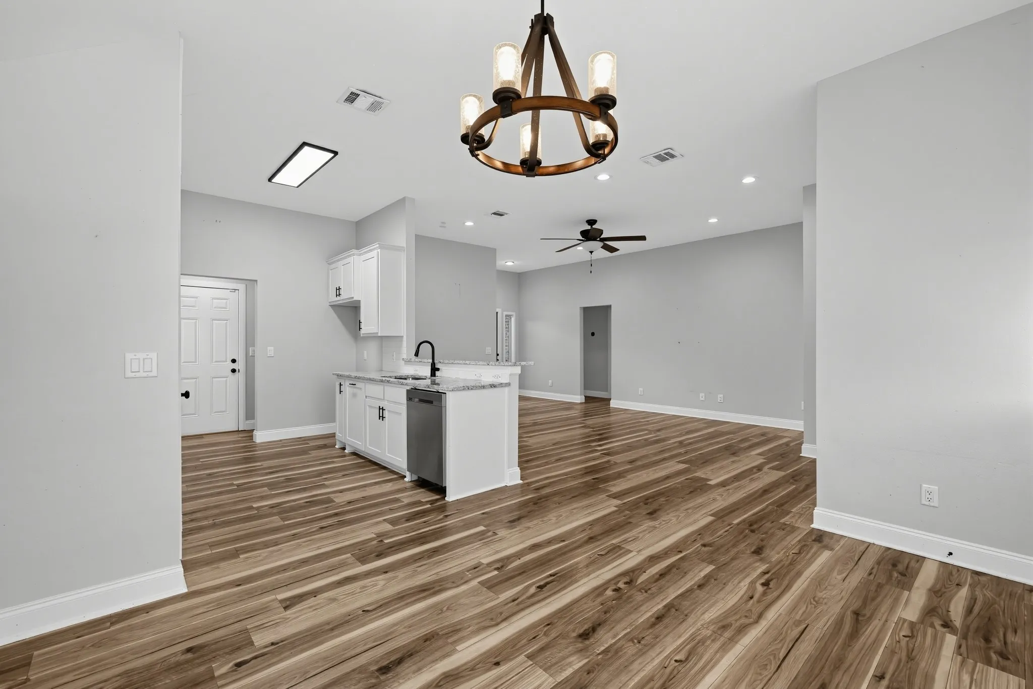 Kitchen featuring white cabinetry, stone-finish countertops, and a stainless steel dishwasher